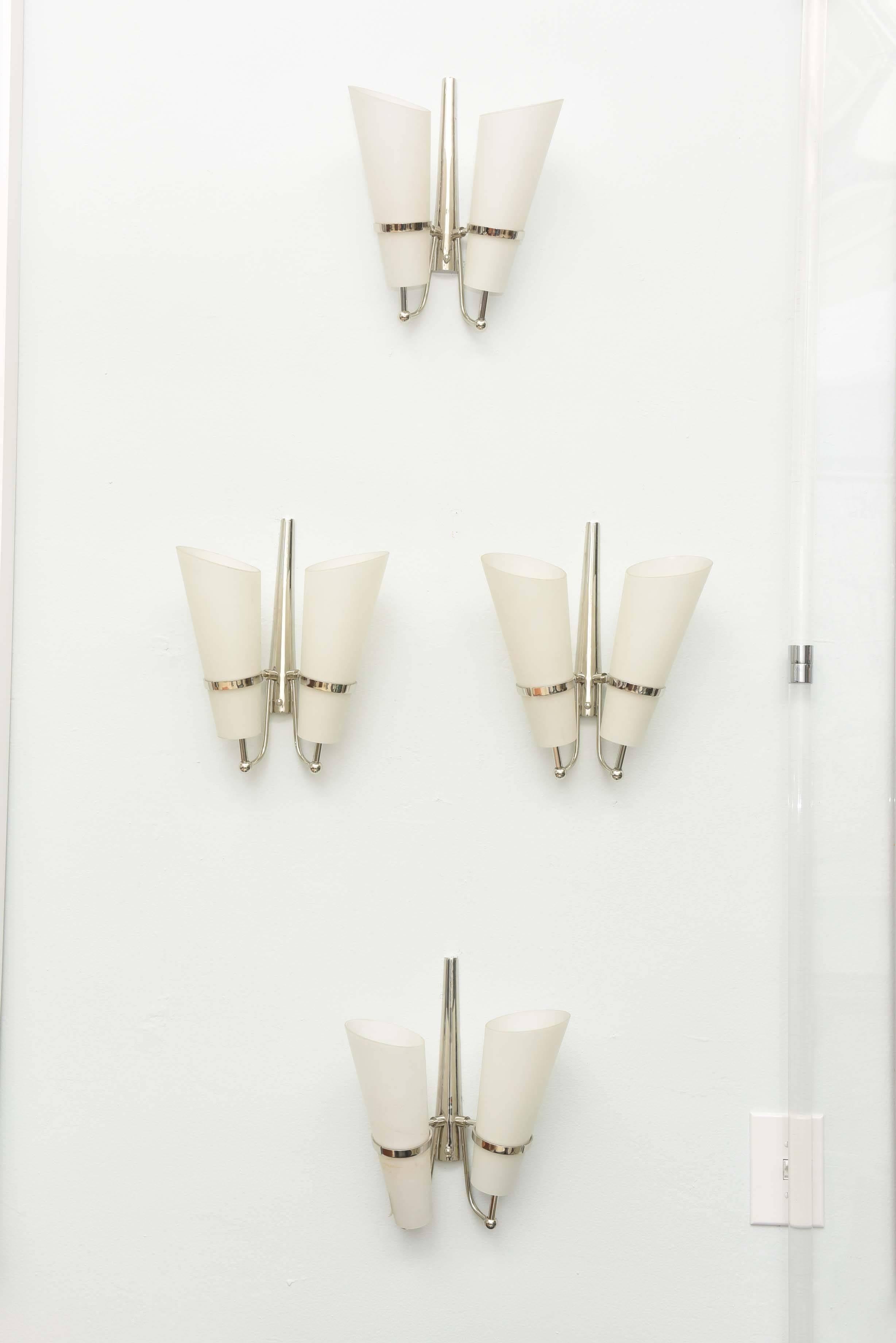 The nickel frame with ring holders for two frosted glass conical tapering shades.