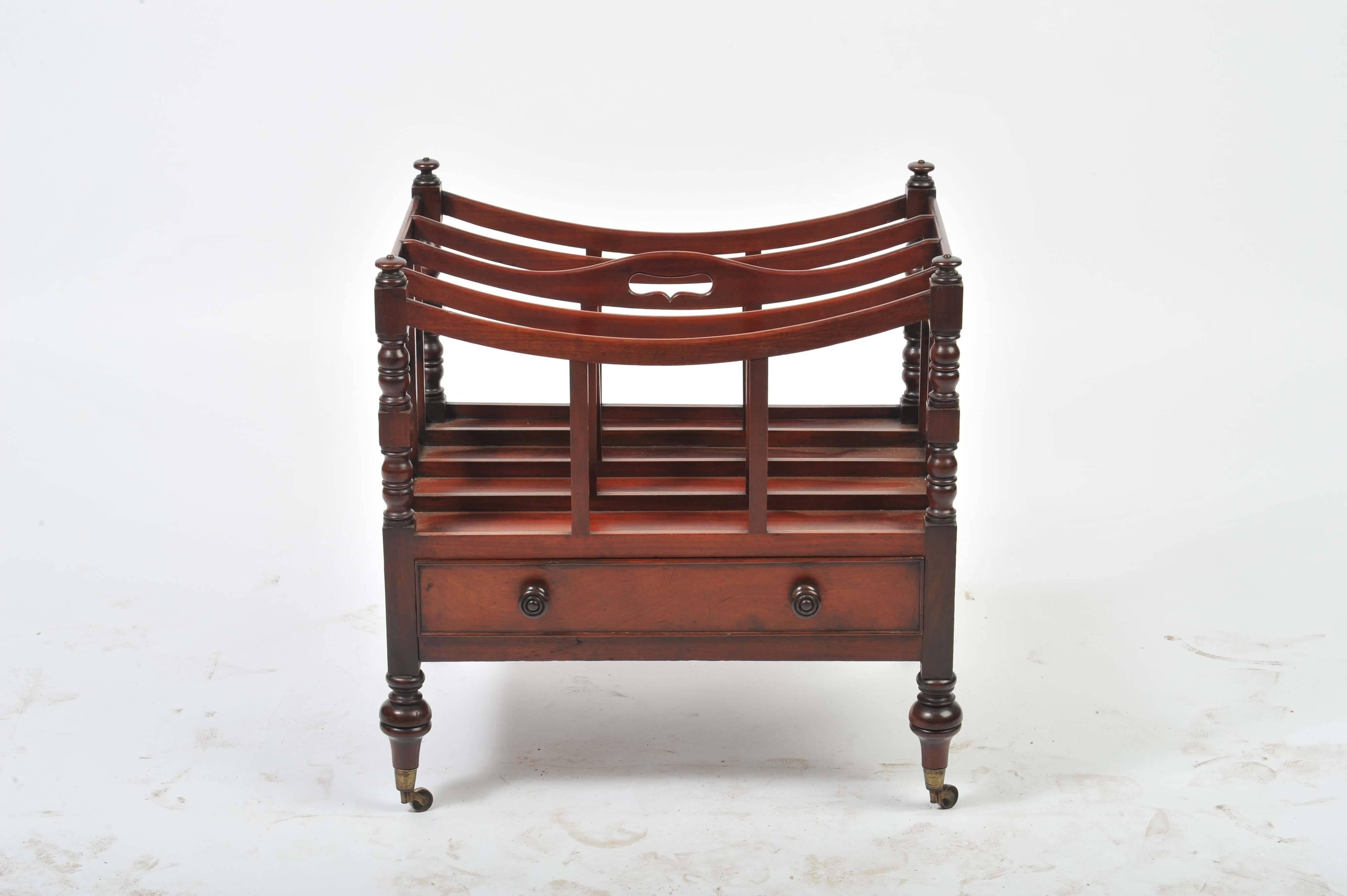 A good quality Regency period Mahogany four division canterbury, having a single drawer and raised on turned tapering legs with the original brass castors.