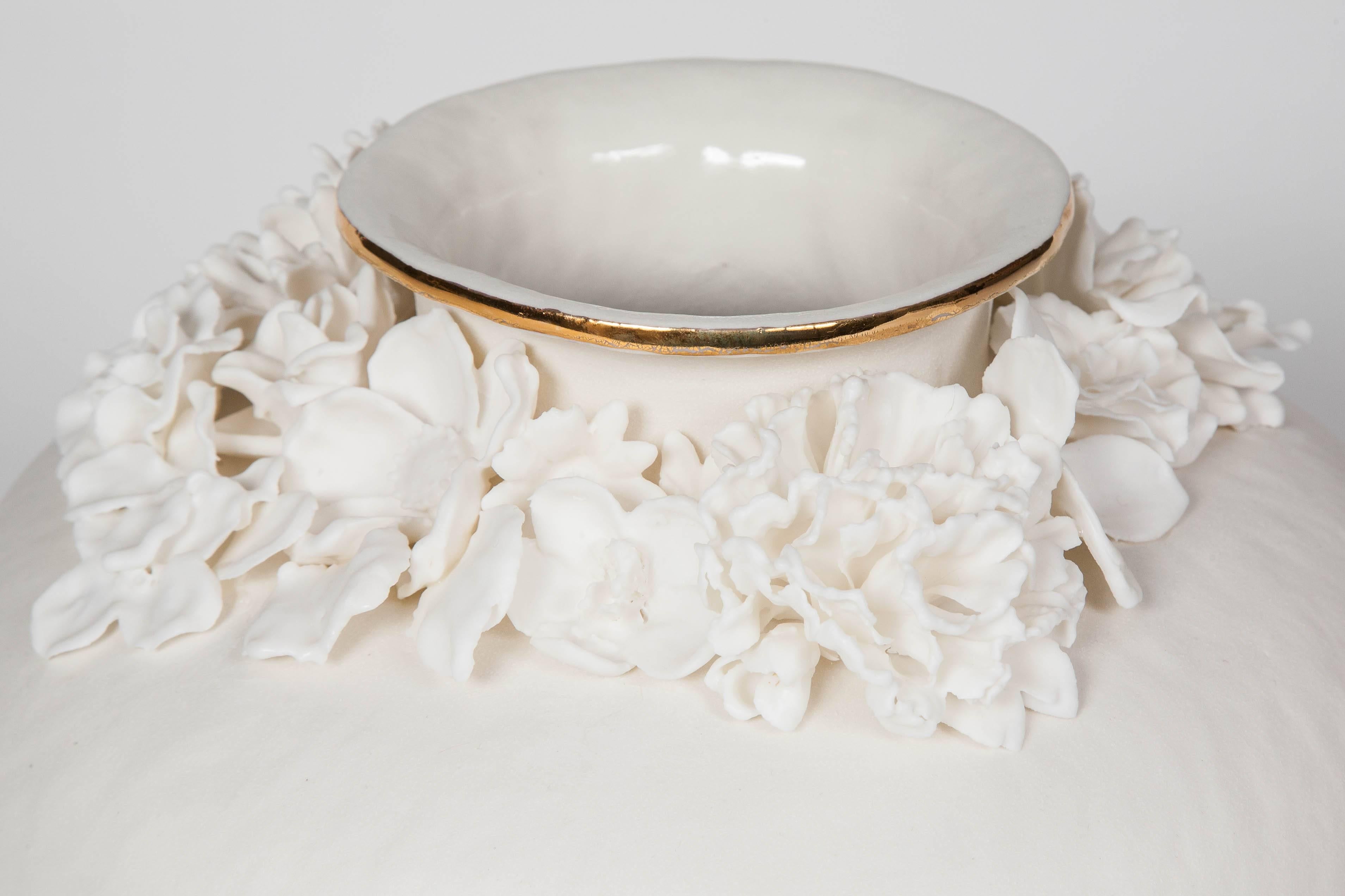 Hand coiled porcelain with Parian flowers and gold lustre detail.

Working as ceramic artist, Hughes specializes in hand building, enjoying working with form and texture and studying its relation to decoration. Her practice is both fueled by and