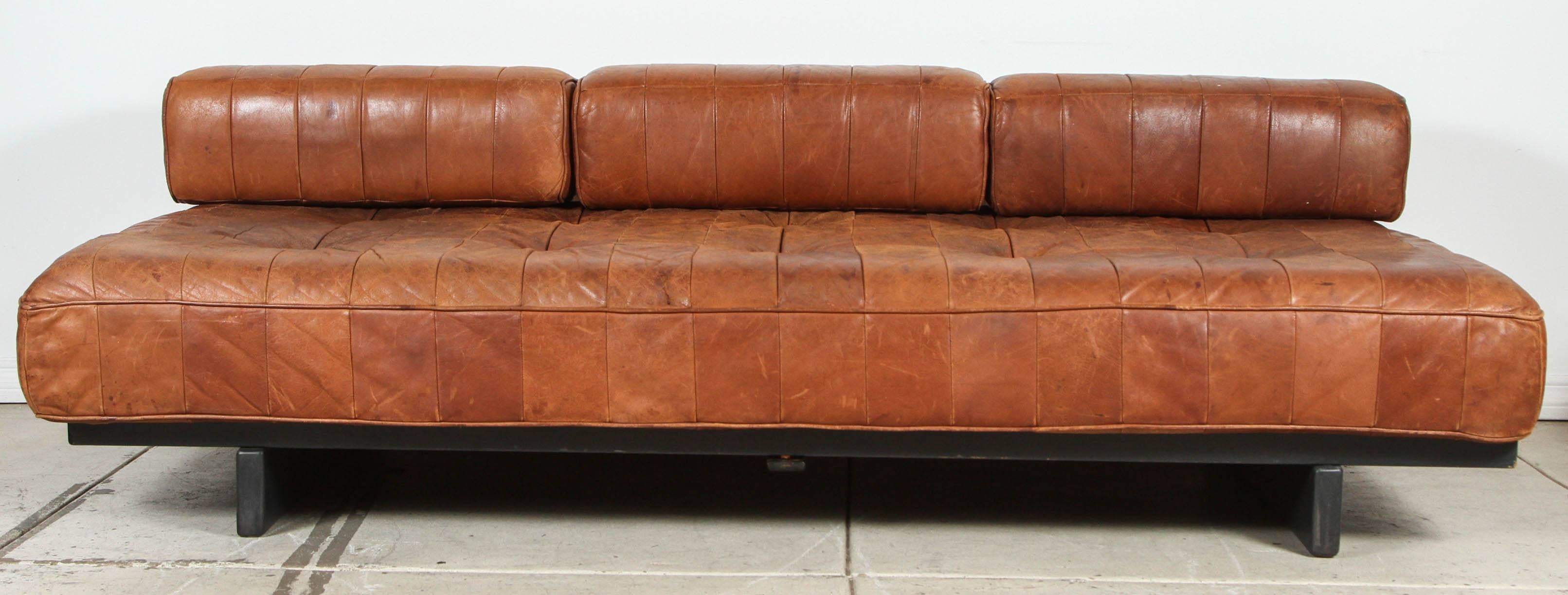 Patchwork leather daybed with three matching back cushions on wooden slat framework. Beautiful patina, foam in good condition.