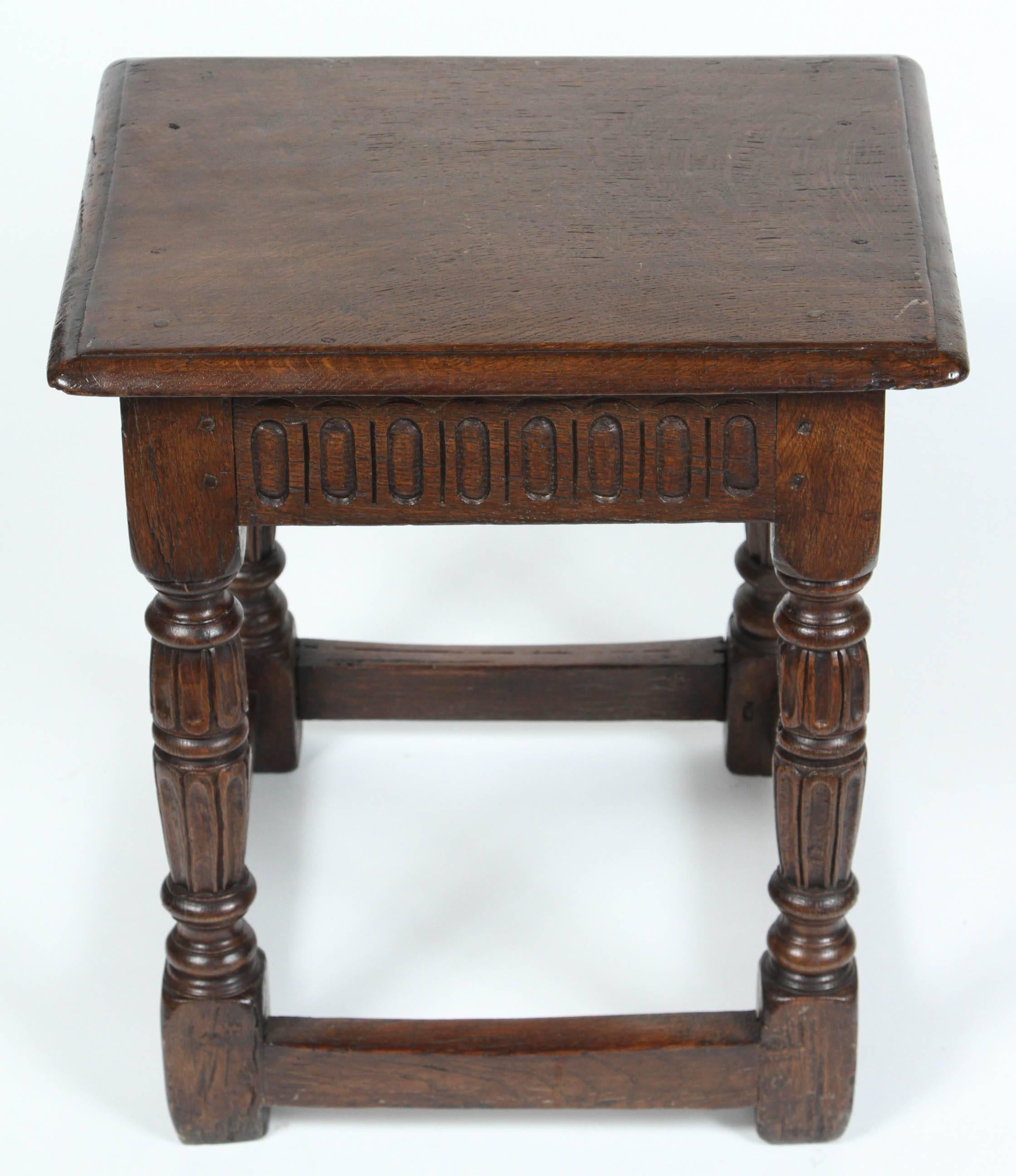 An early 17th century English joint stool. One of a near pair.