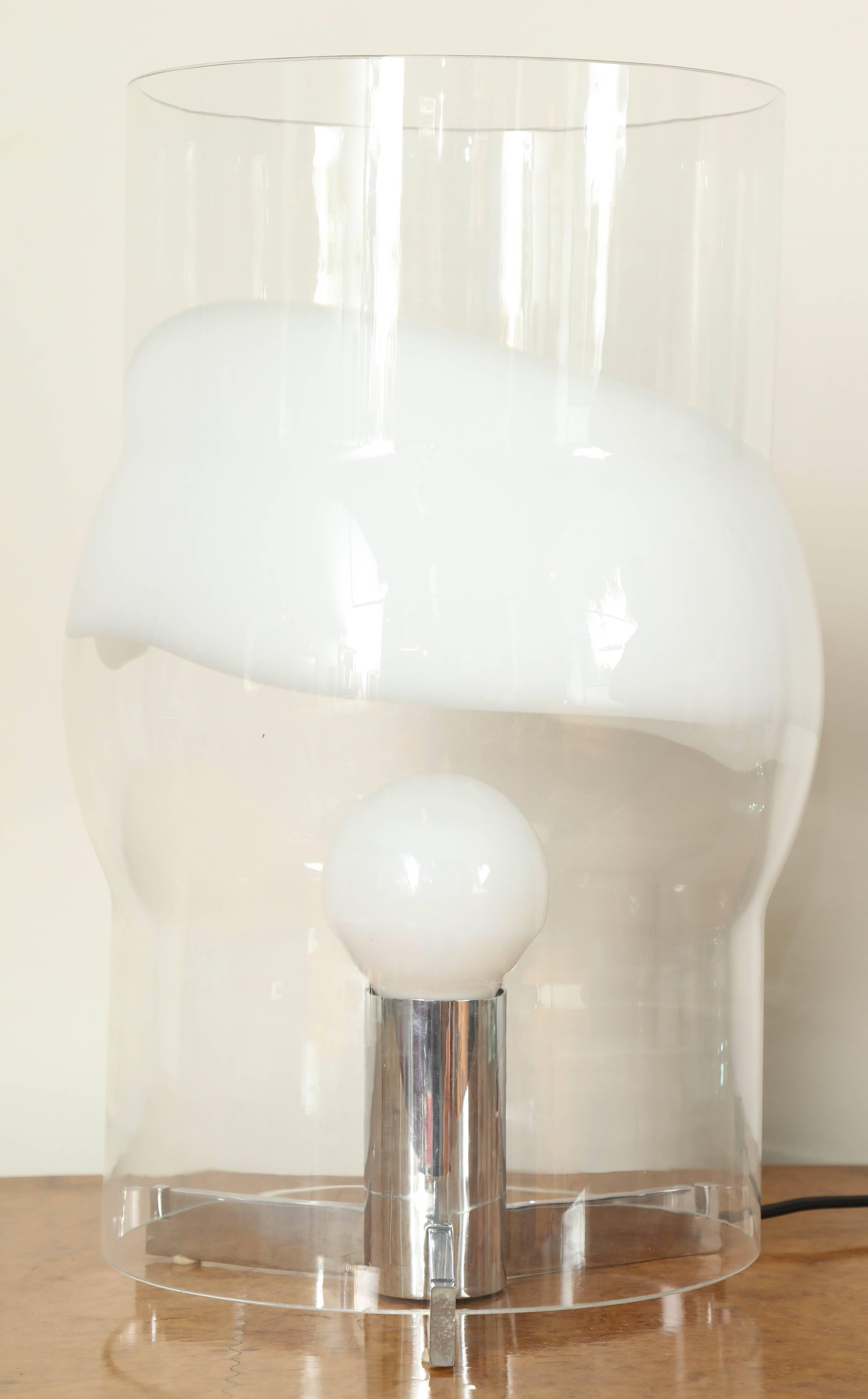 Stunning modernest table lamp designed by Carlo Nason for Mazzega, made in Venice 1970. Blown clear glass shade with a band of white that rests on three chrome arm base, great quality, takes one large incandescent bulb.
 