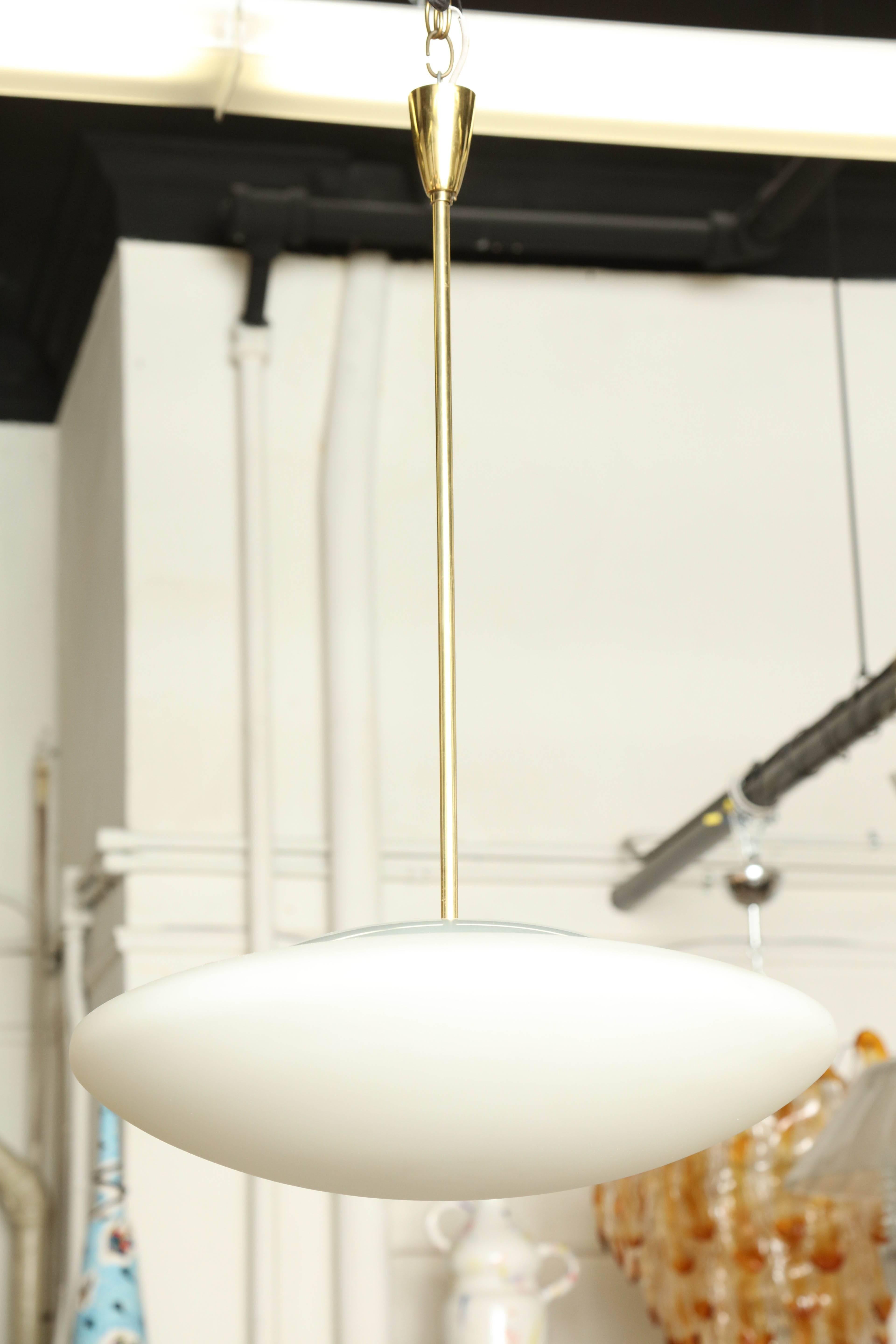 Modernist pendant light made in Milan 1950 by Fontana Arte, white blown opaline glass shade with a clear cover, where the brass rod connects to shade there is a brass piece with openings for the heat to escape, beautiful made, great in hall kitchen