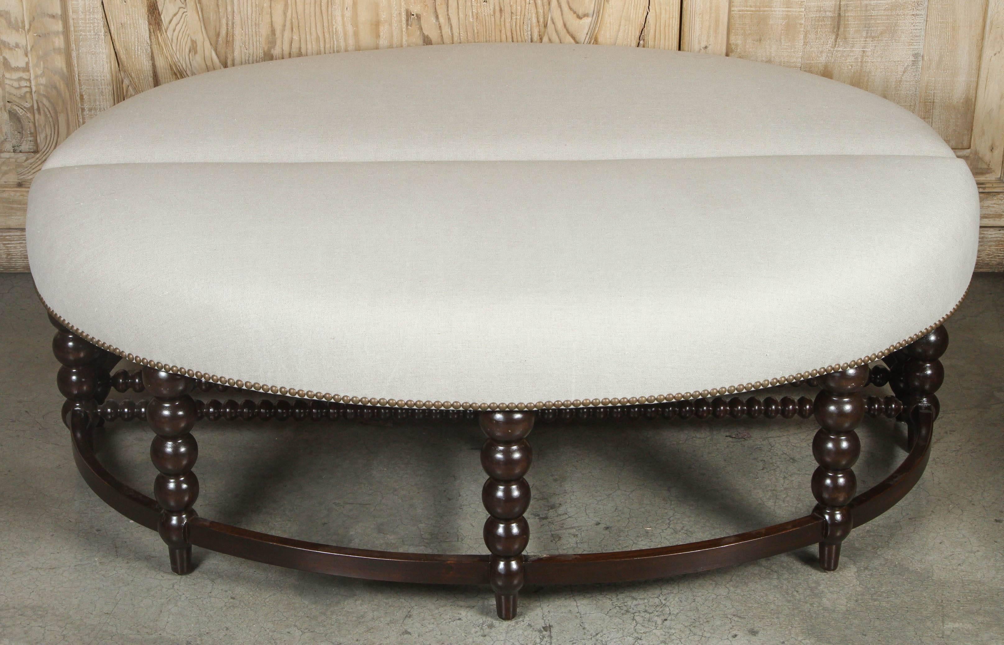 Pair of vintage spool leg half circle ottomans. Newly refinished and upholstered in flax linen with nail head trim.