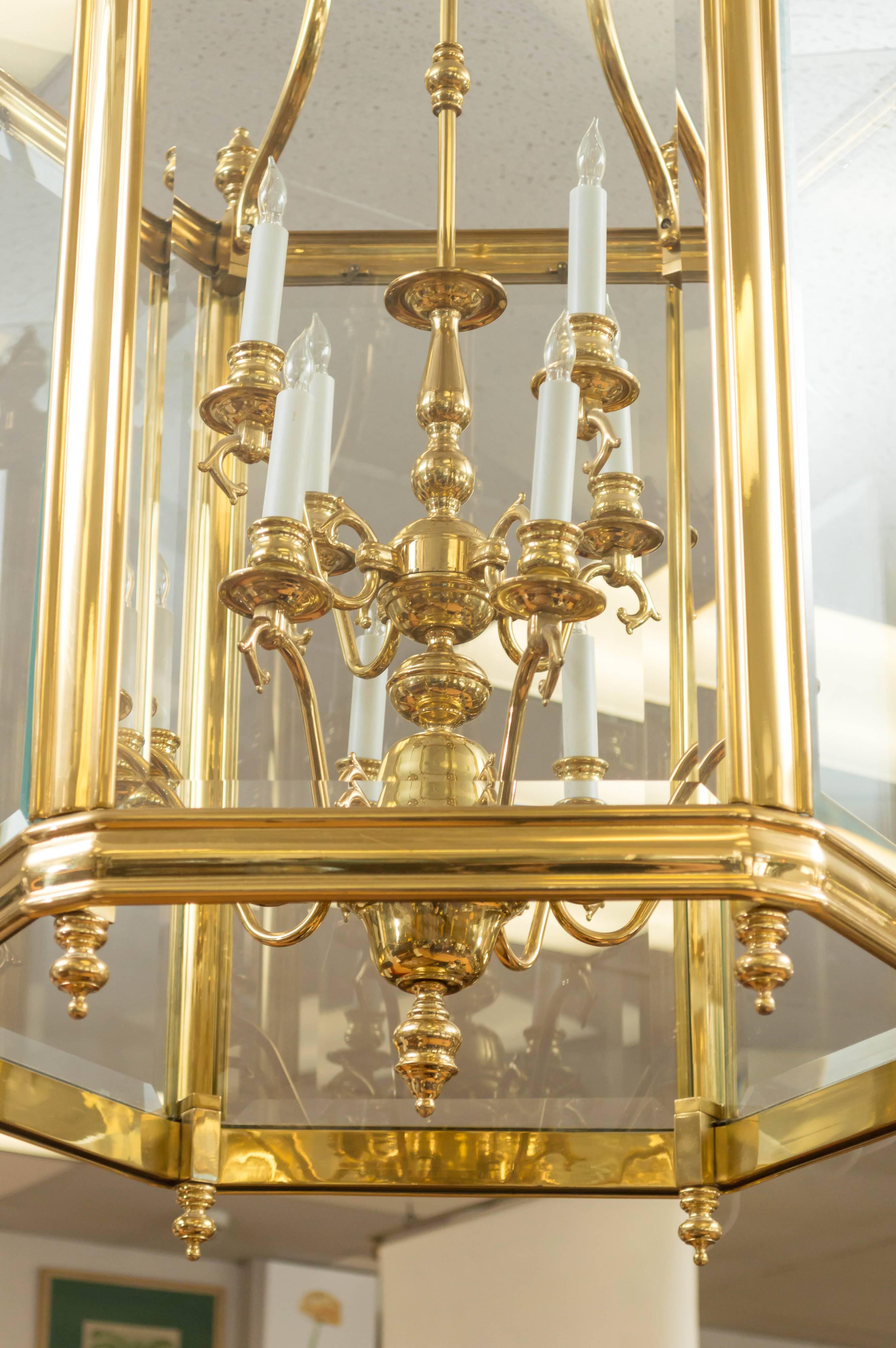 A grand entry demands equally grand lighting and this majestically scaled brass and glass lantern pendant regally fits the bill.

The sculptural Dutch-style tiered chandelier at its center has elegant laurel swag arms that hold aloft 12