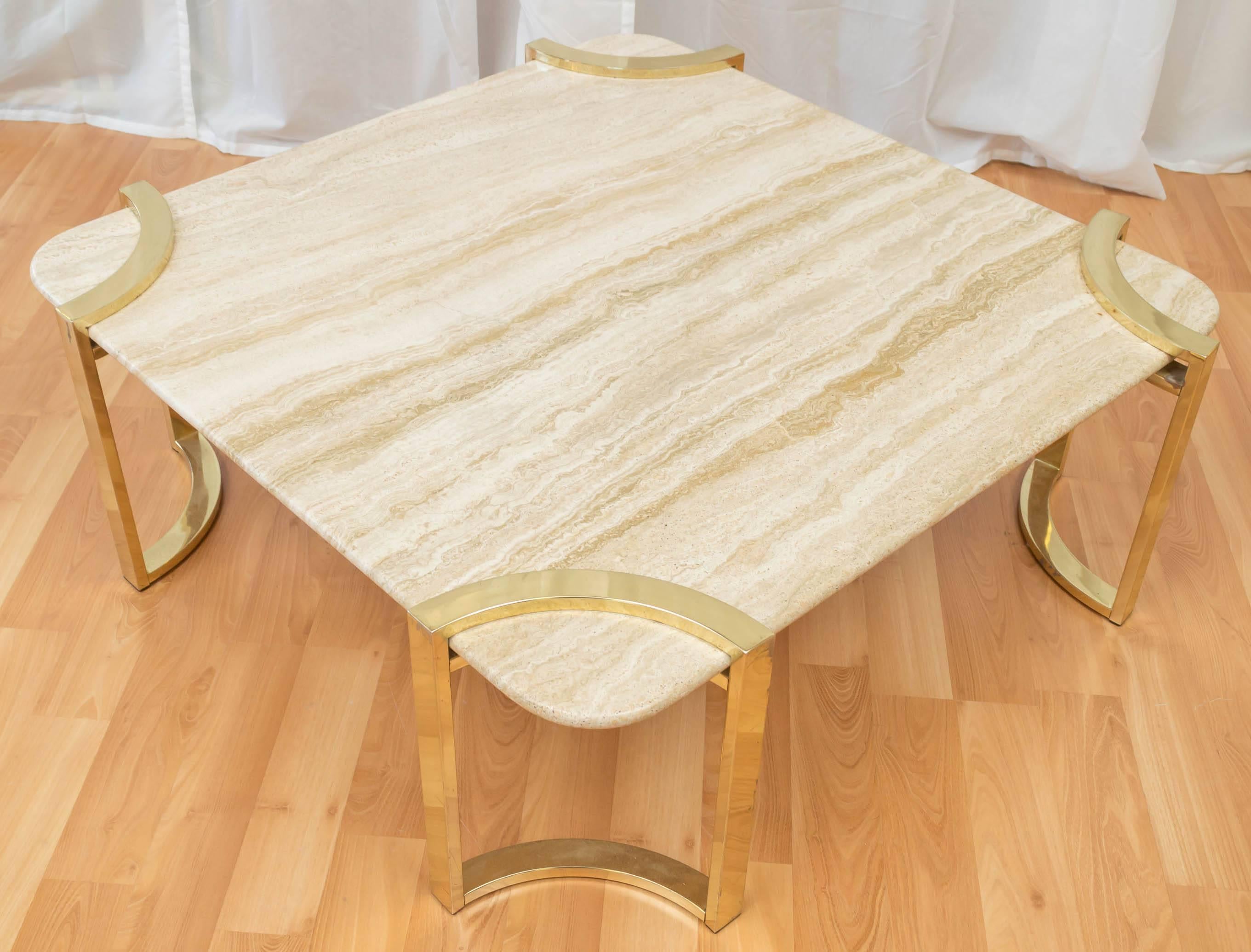 A generously proportioned Italian travertine coffee table with brass-plated steel base.

The clever curved geometry of the four independent, suspension-mounted brass legs calls to mind the designs of Milo Baughman. The .75 inch single slab