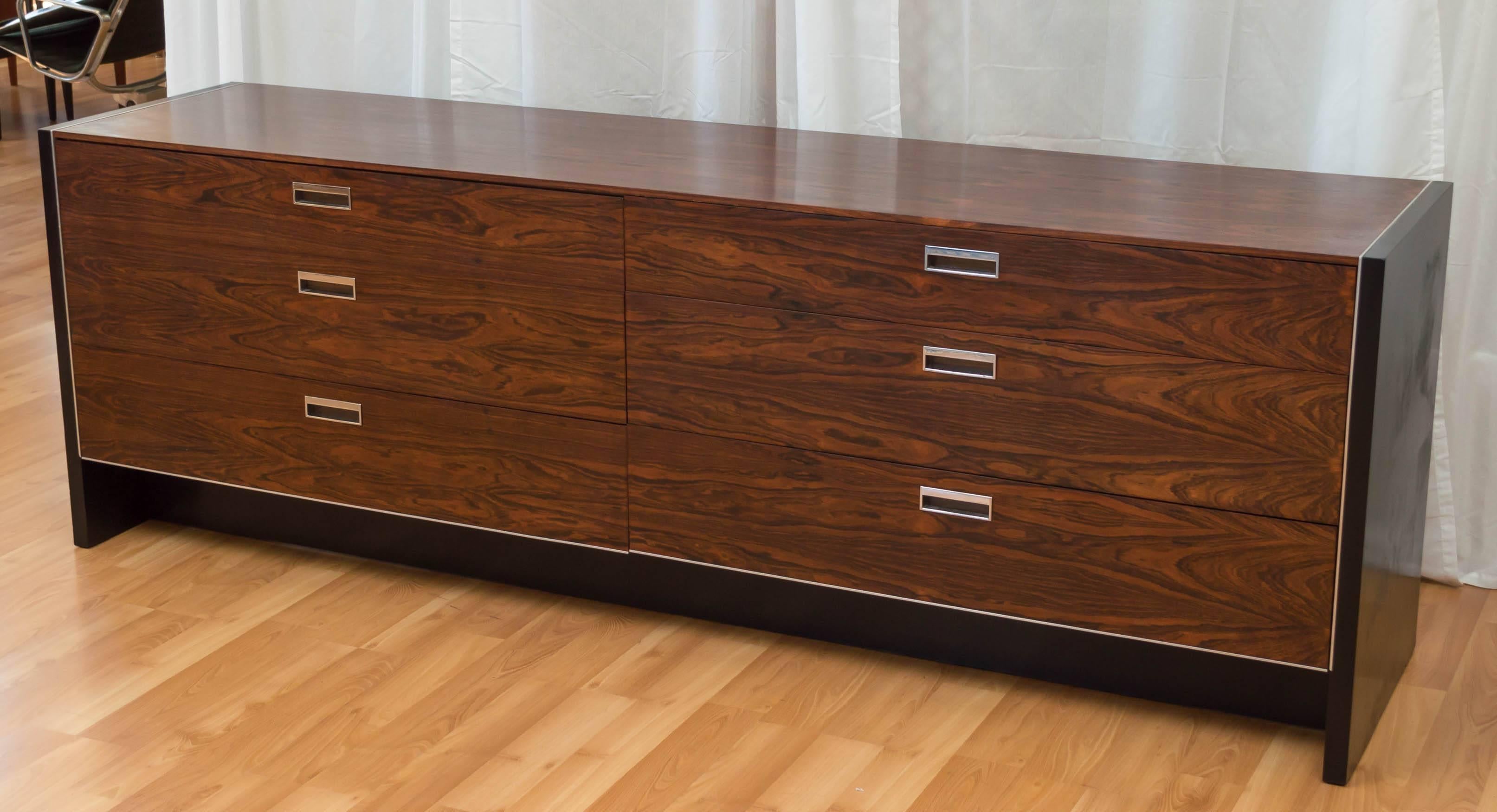 An exceptionally handsome and expansive six-drawer rosewood dresser with ebonized oak frame and chrome hardware by Robert Baron for Glenn of California.

Richly grained rosewood veneer is presented in one gorgeous piece on top, and is beautifully