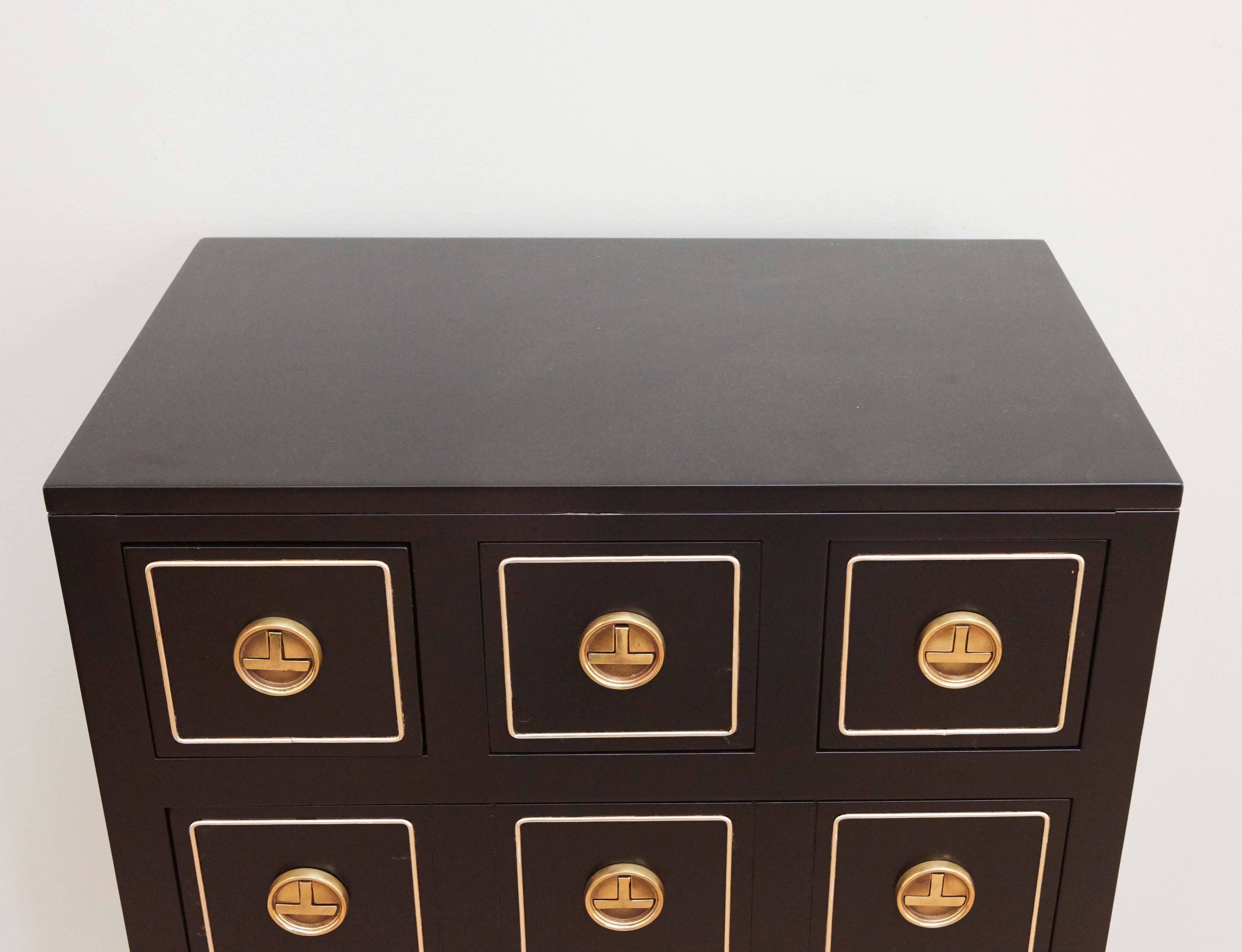 Small dresser with brass hardware. Three drawers on top row. Bottom two rows have faux three drawers front but open as two larger drawers as shown in image 4.
In the style of Dorothy Draper.