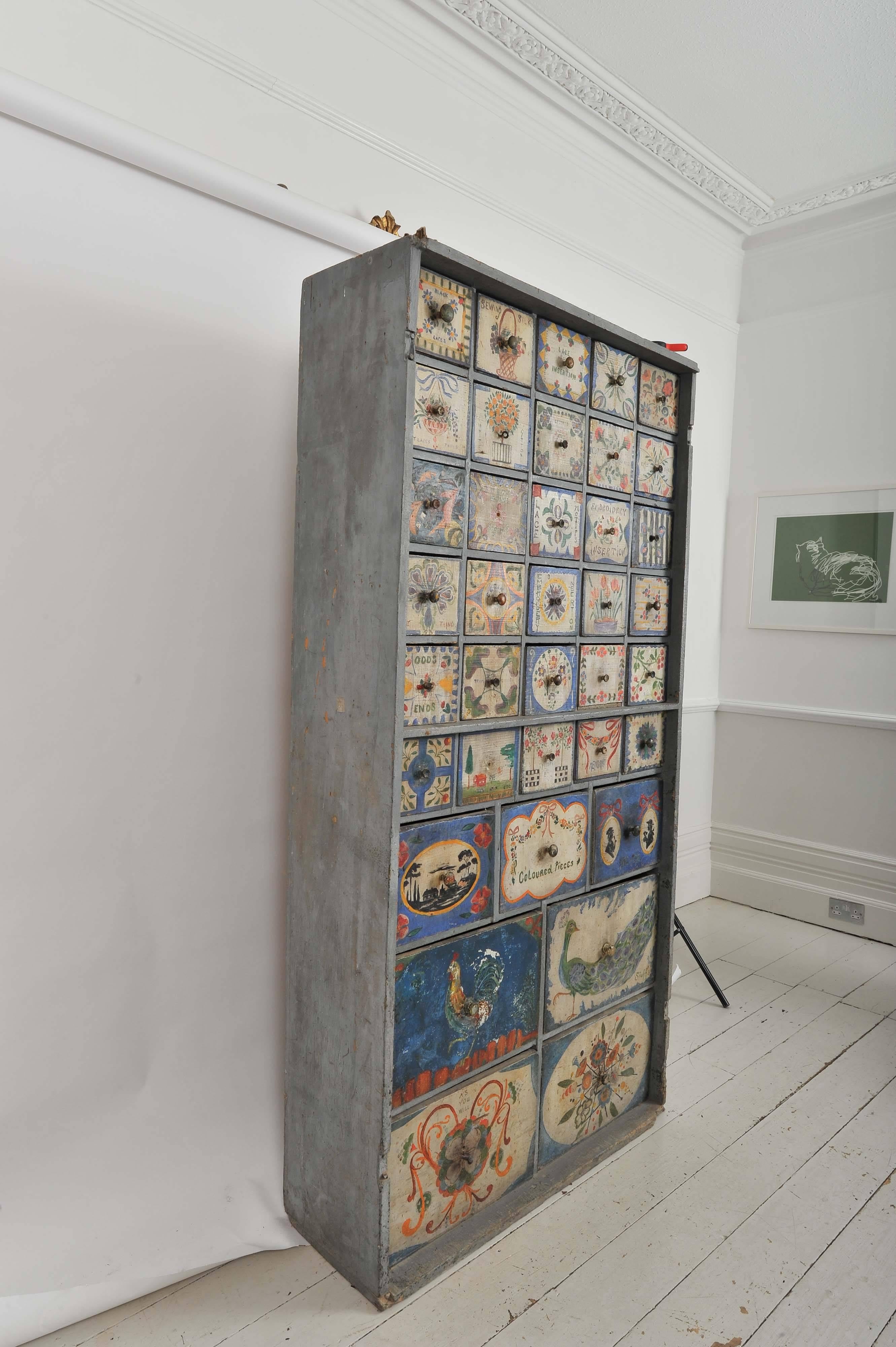 A highly original and unique tall 19th century haberdashery cupboard with 37 hand decorated drawers. Each drawer is painted with a unique design.