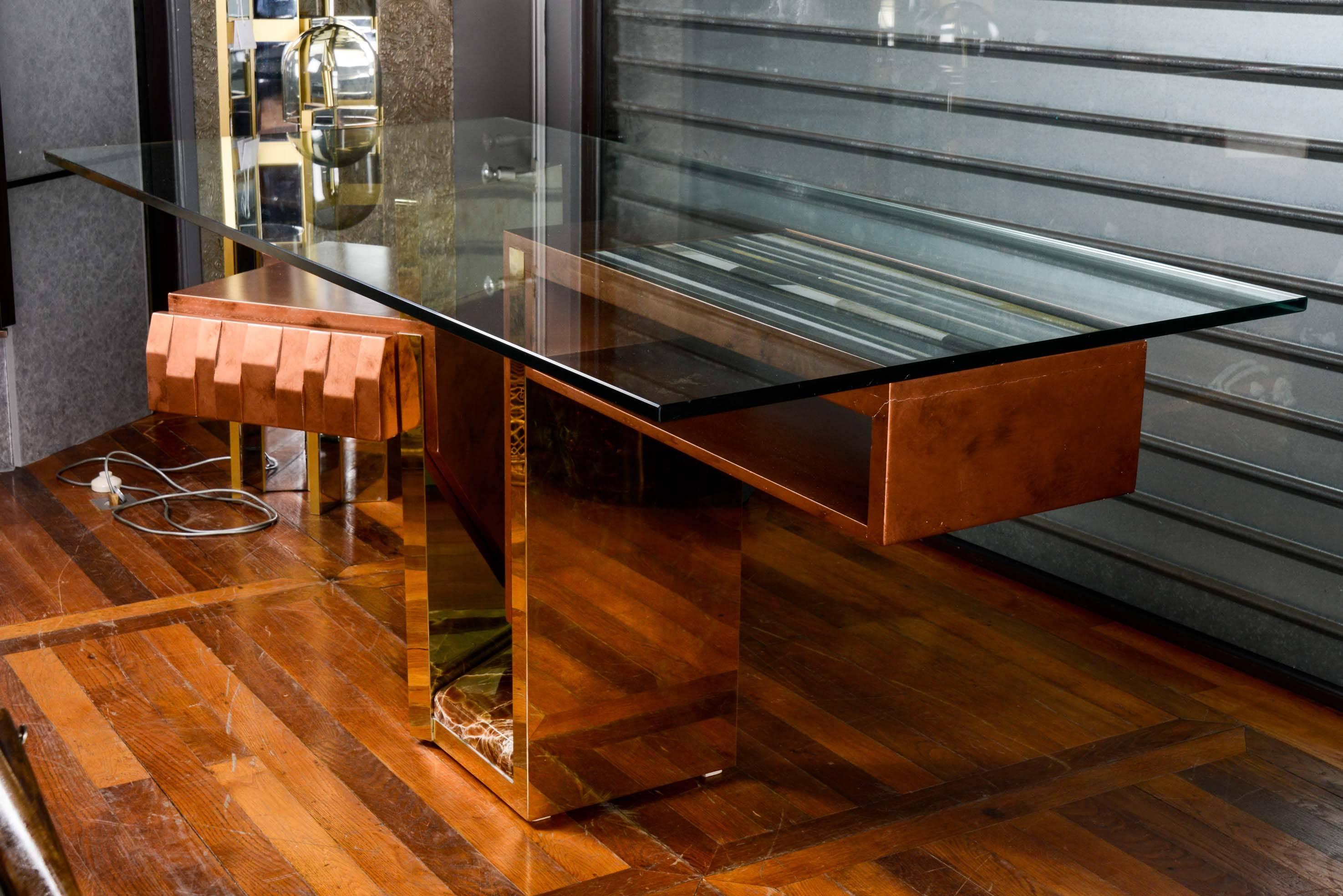 One-drawer desk with onyx, top in glass showing a ceramic plate.