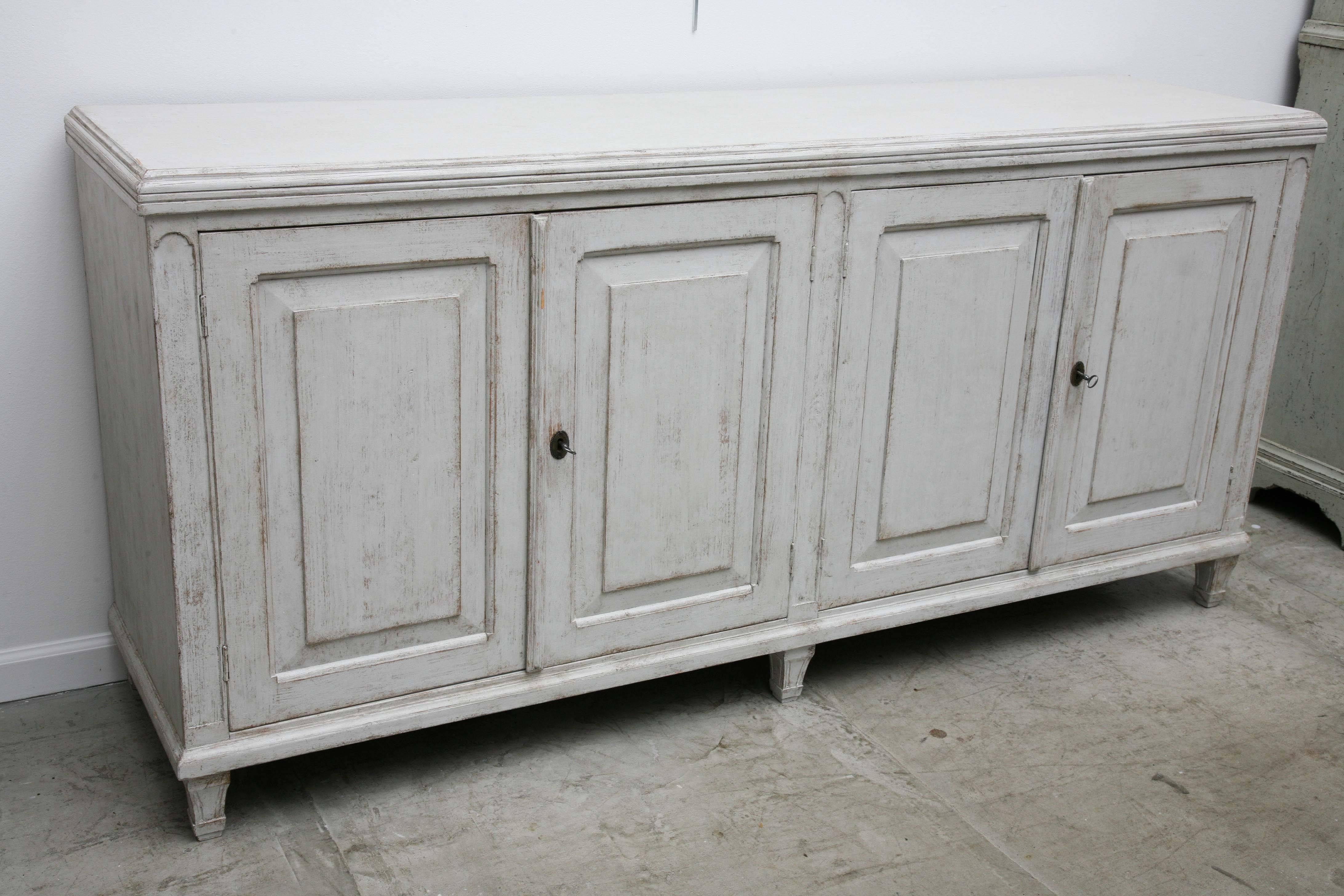19th century unusual large Swedish antique four door painted sideboard, with
raised panel doors, crown moulding border around top border, one inside shelf,
Gustavian grey colour.