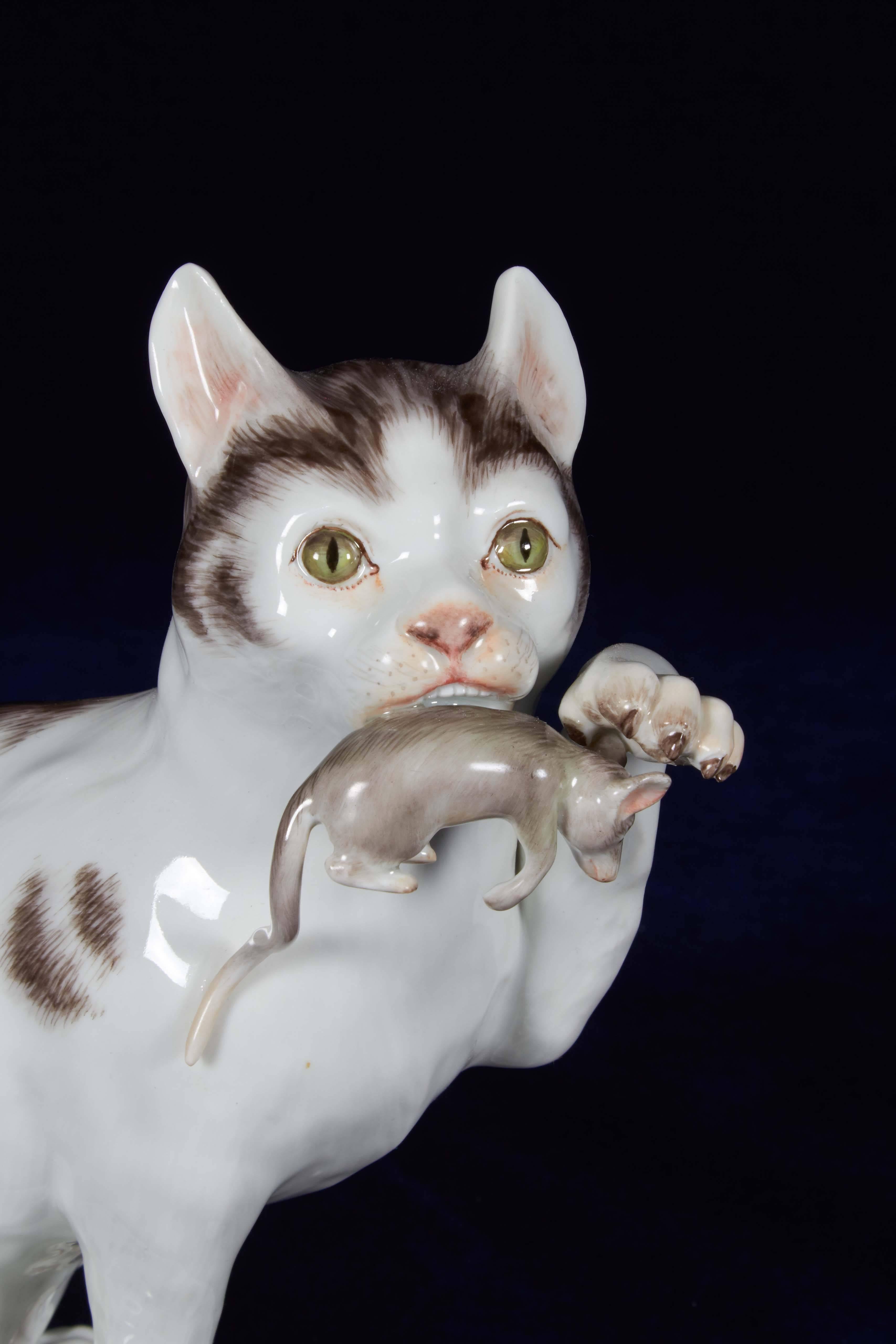 A Meissen Porcelain group of a seated cat, holding a catch in its mouth, finely painted with naturalistic colors,
Germany, circa early 1900s.