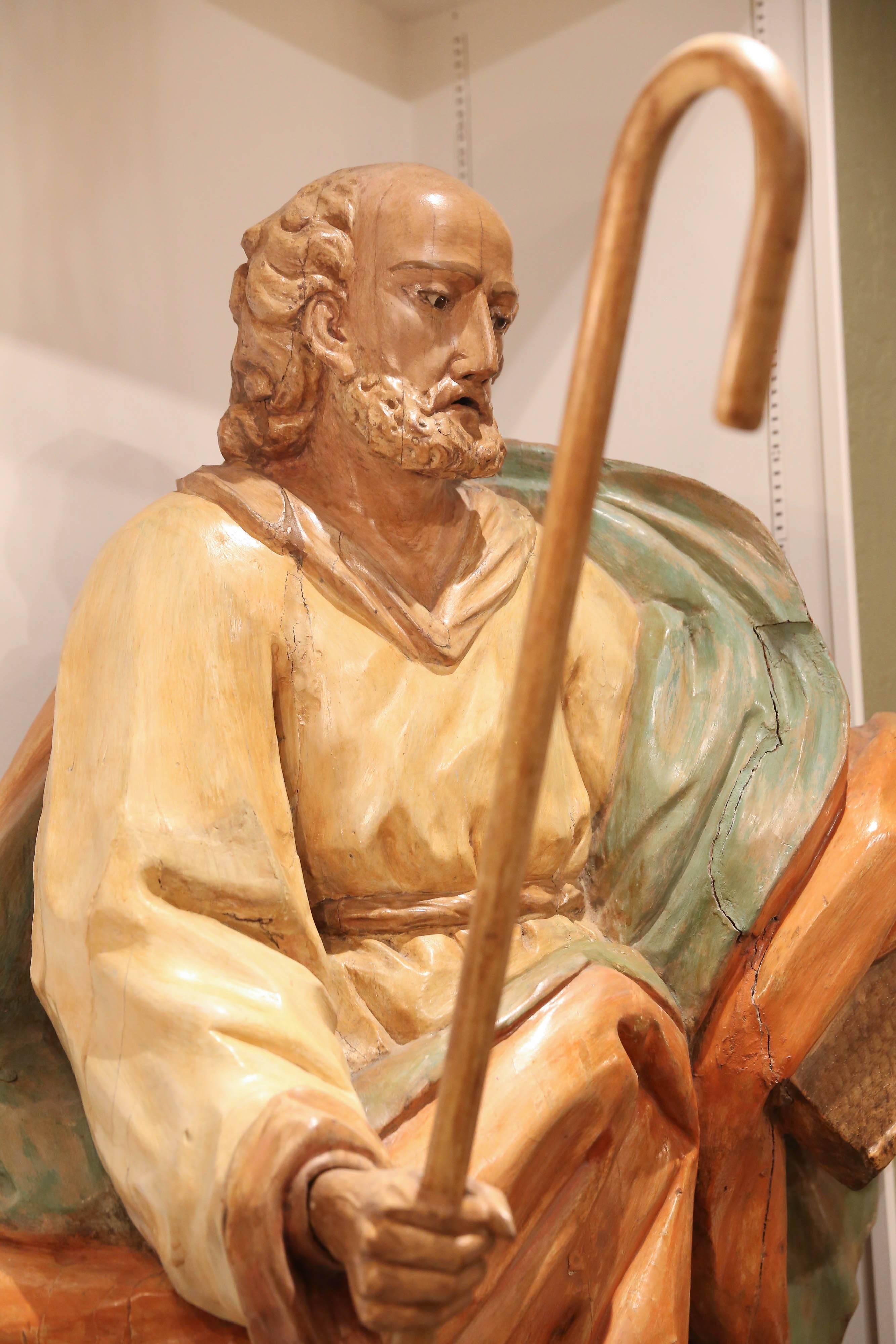 Large wooden statue from Italy depicting a disciple. Clothed in robes of
gold, russet and green colors. The figure holding a bible in one hand
and a staff in the other hand.