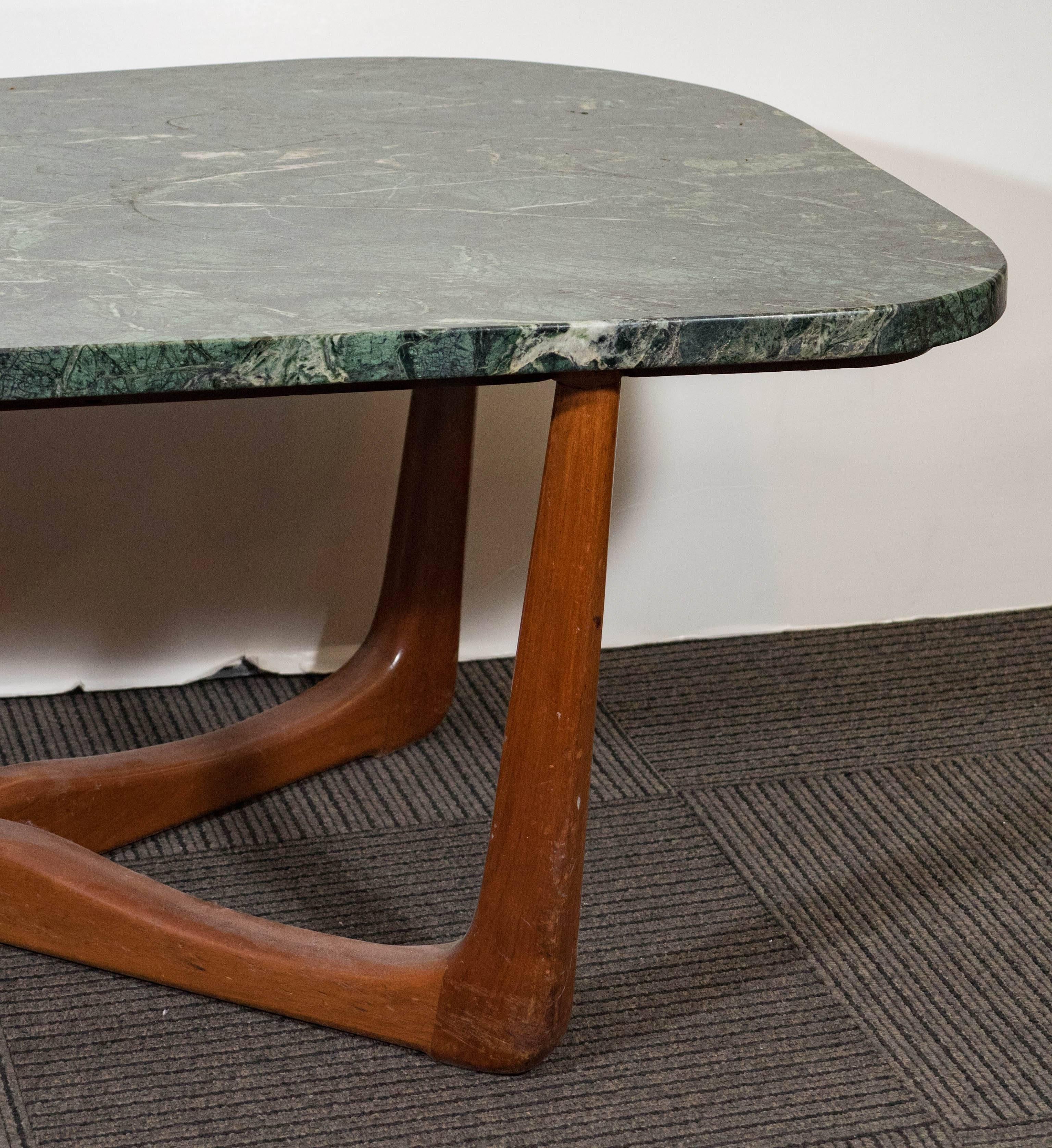 A coffee and cocktail table, produced circa 1970s in the style of designer Vladimir Kagan, with asymmetrical top in green marble, above a fluid, three point wooden base. Very good vintage condition, with age appropriate wear to finish on wooden