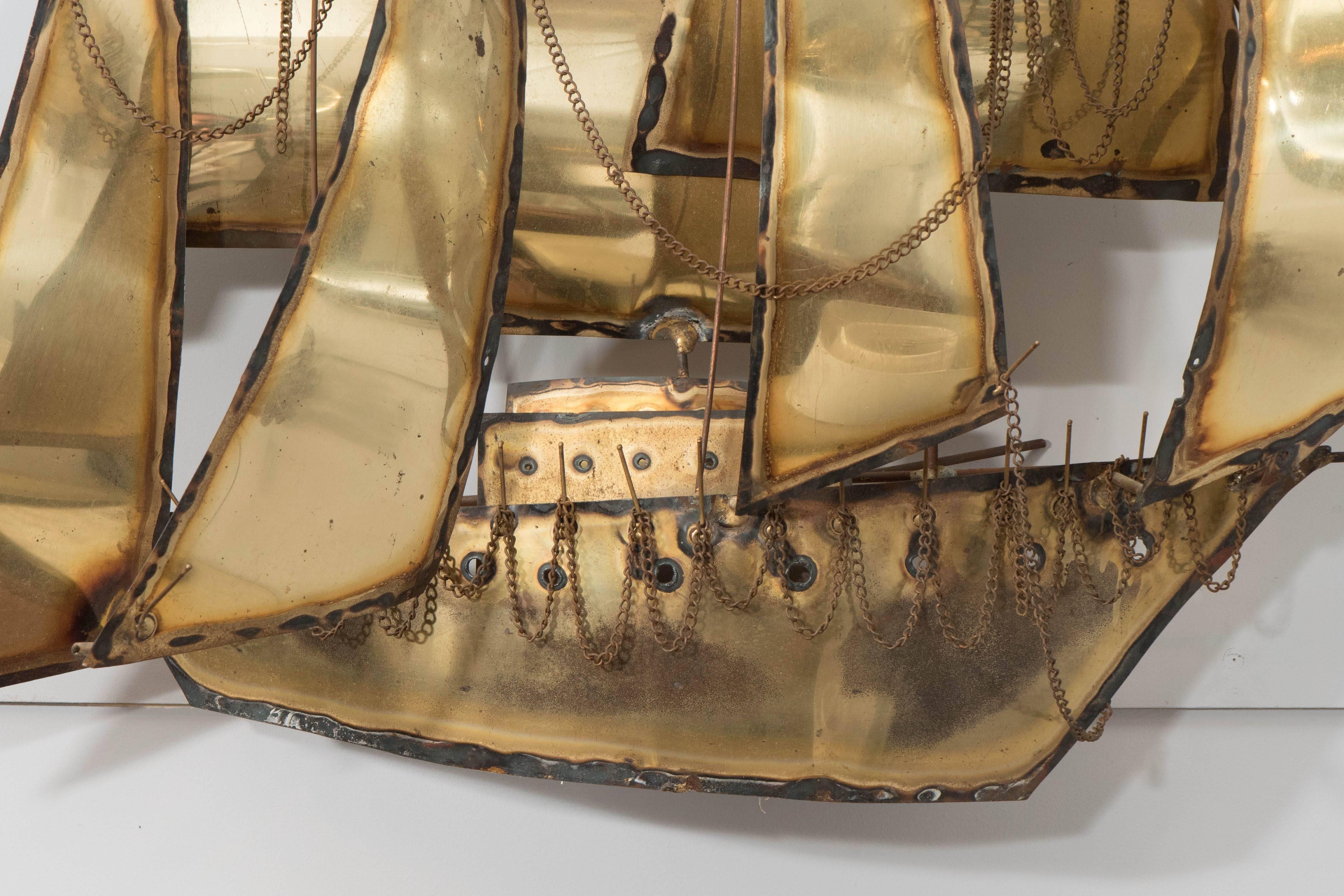 A 1960s sculptural wall hanging, designed in the Curtis Jere Brutalist manner, composed of torch cut and soldered mixed metals, depicting an impressive sailing ship. This piece is in very good vintage condition, consistent with age and use; repairs
