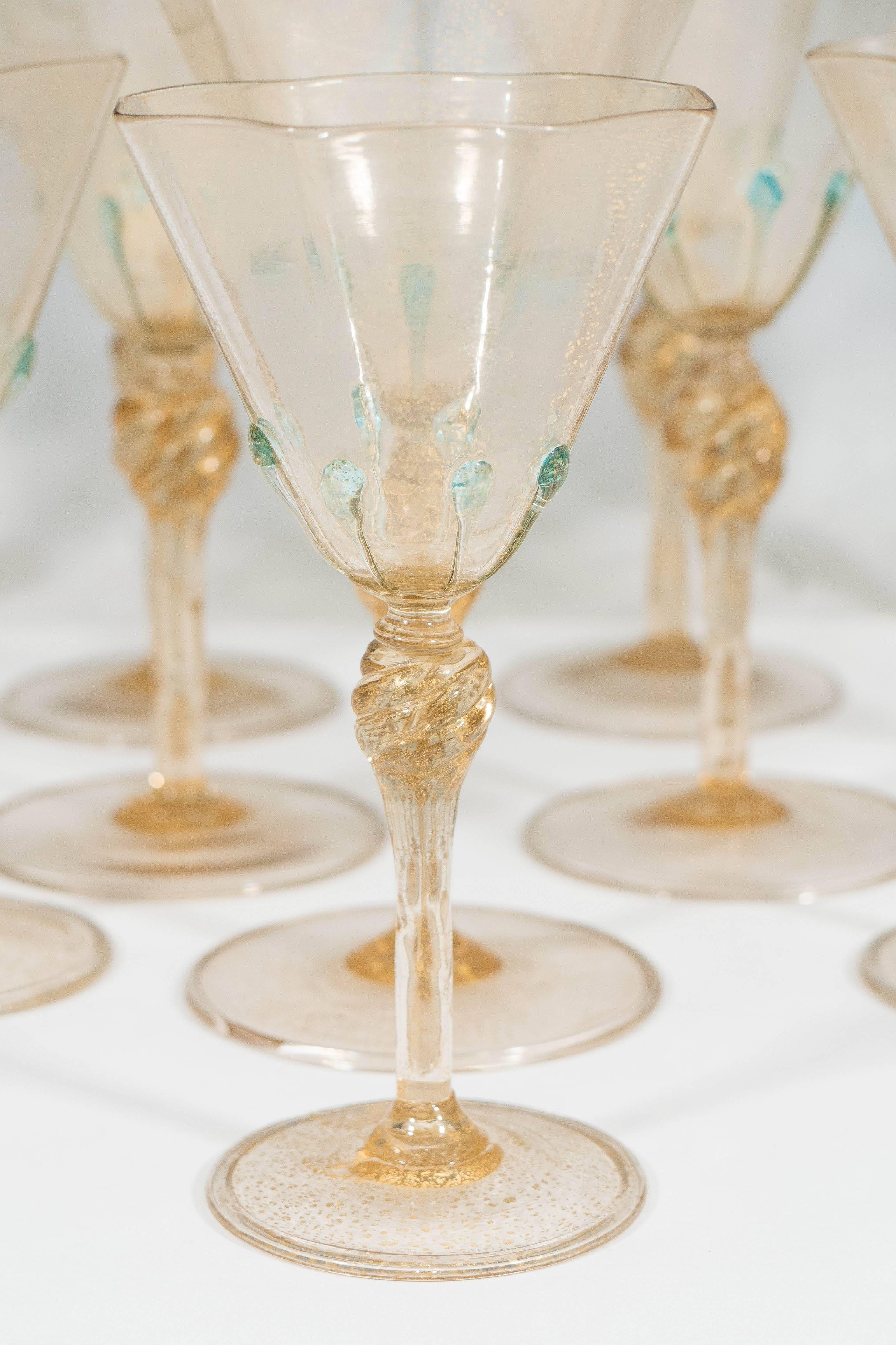 This set of 12 thin walled, handblown glass stems with gold leaf, produced circa 1920s to 1930s by Salviati, includes nine wine goblets and three cordial glasses, with octagonal form rims, decorated with blue drops, on stems with swirled bulbs. The