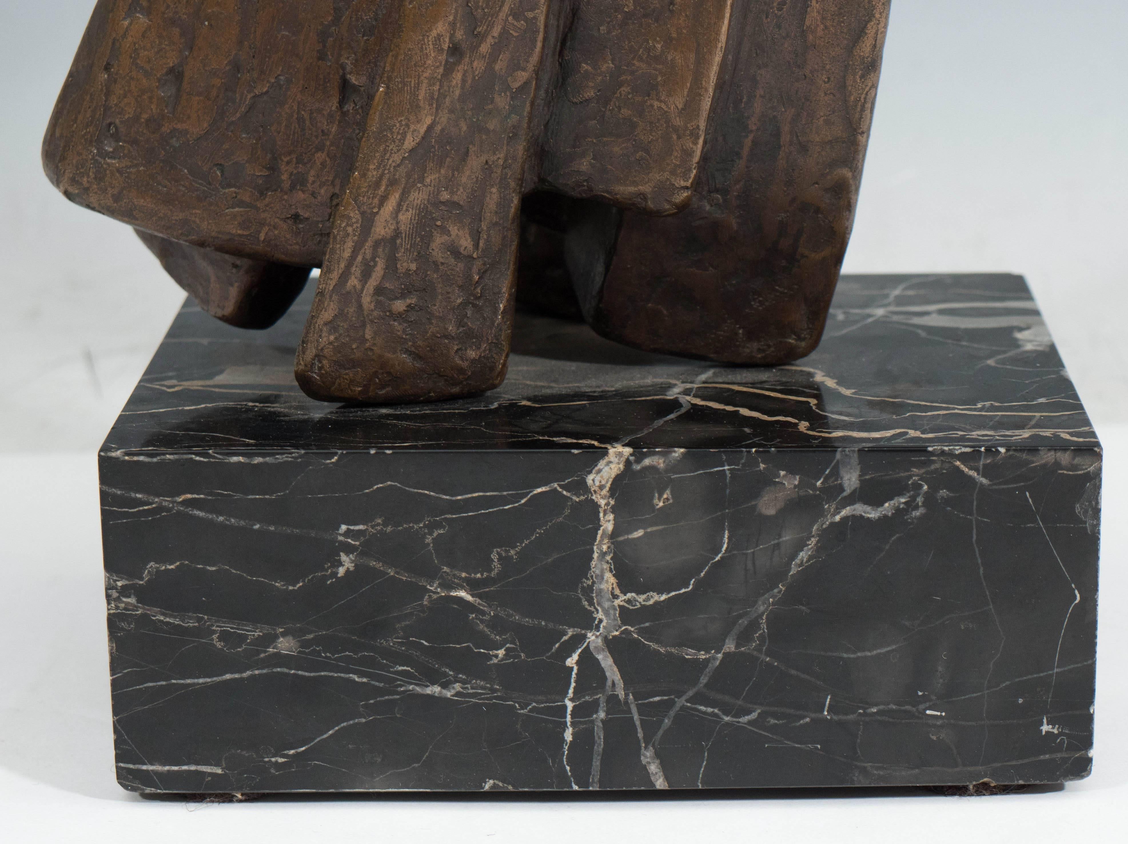 An abstract sculpture in textured bronze, circa 1960s, deftly mounted above a black marble base with veining, signed [D. Angelo A/P]. Both sculpture and base are in very good condition, consistent with age.