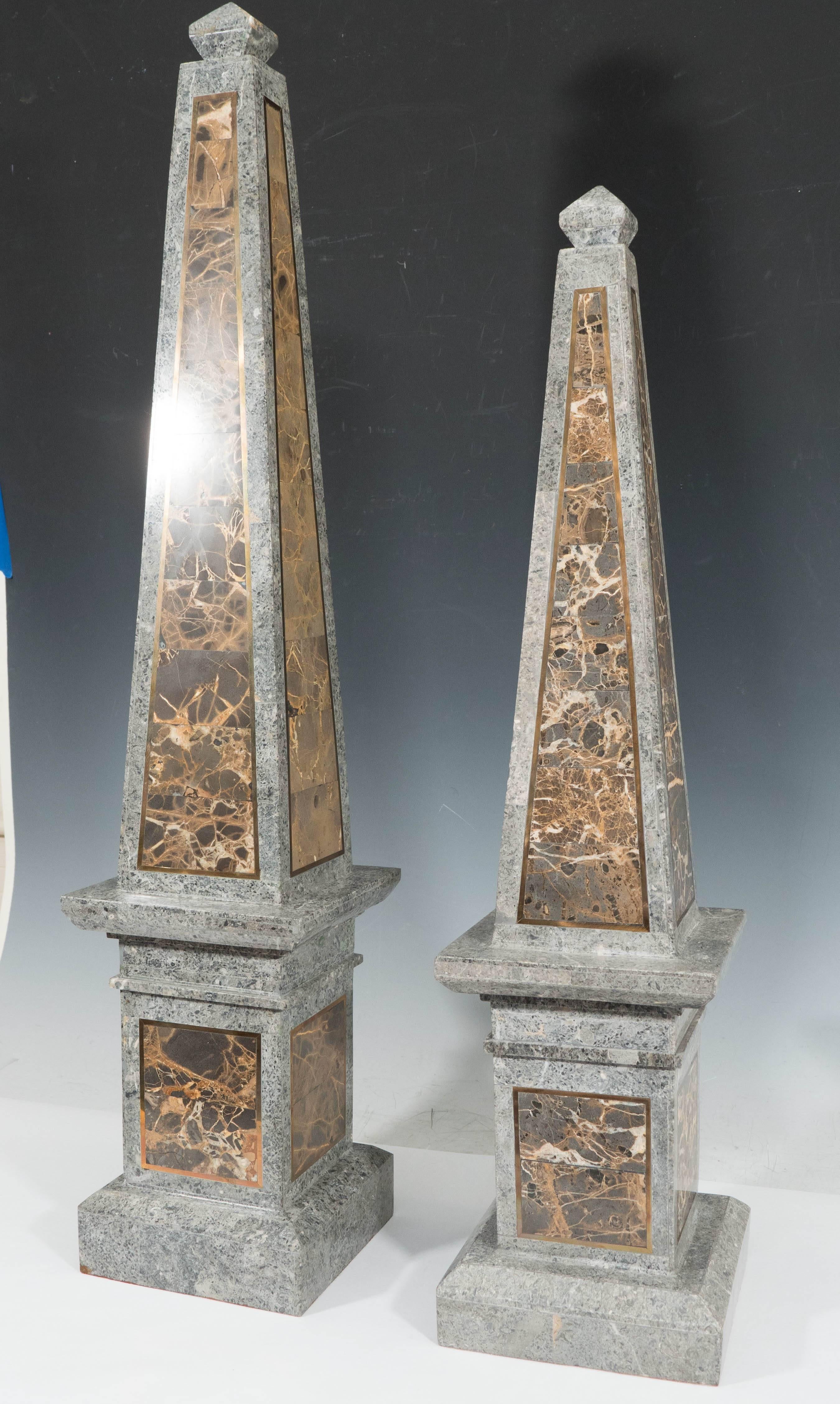A pair of decorative obelisks of small and large proportions, produced circa 1980s by Maitland-Smith, each in gray and colored tessellated marble, surmounted by diamond form finial. The obelisks are in excellent condition, consistent with age and