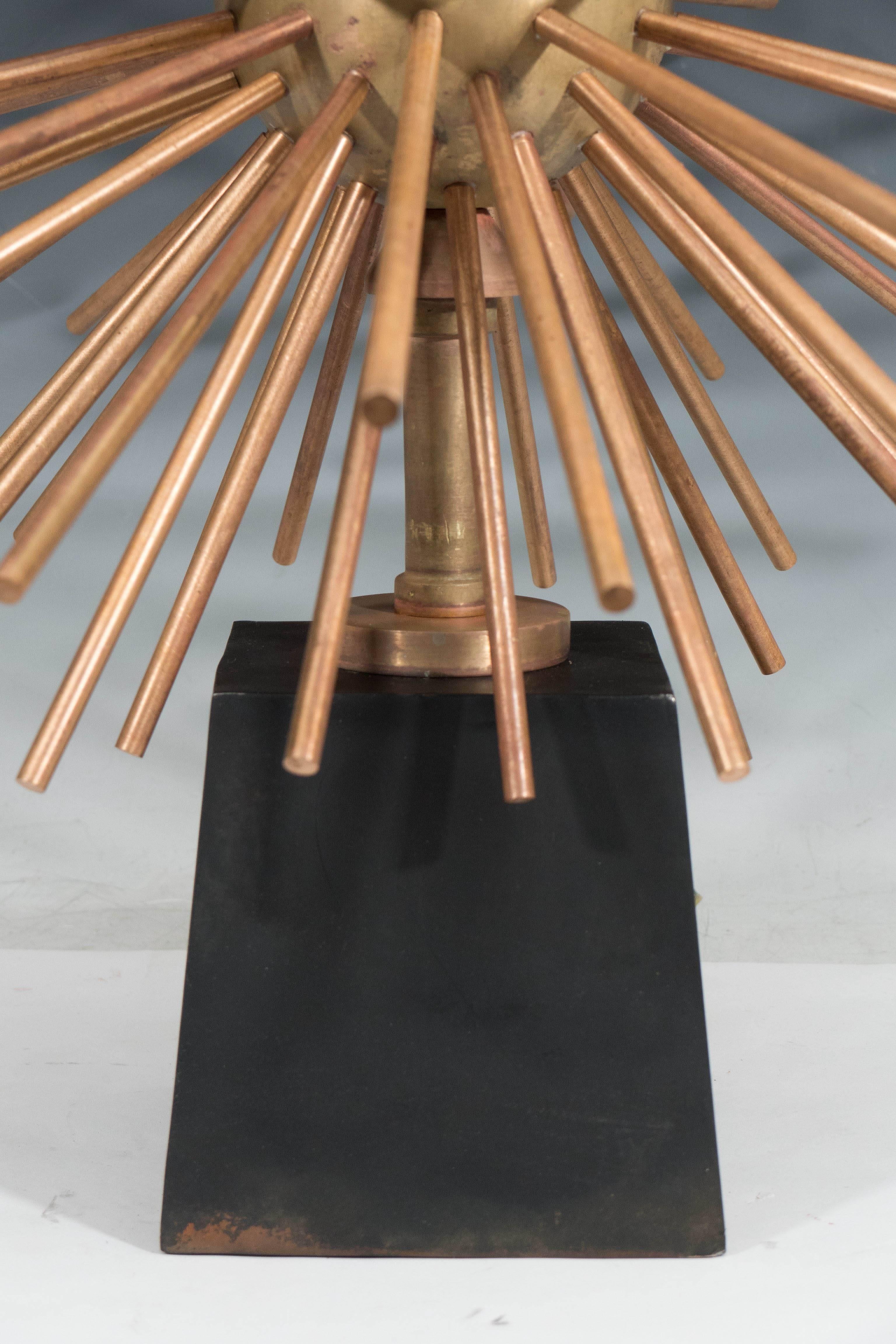 A pair of bronze Sputnik table lamps by designer Arturo Pani, produced in Mexico circa 1960s, each including double cluster sockets over bobbin styled stem and nucleus, surrounded by lengthy spires, on tapered square iron base in black. Despite