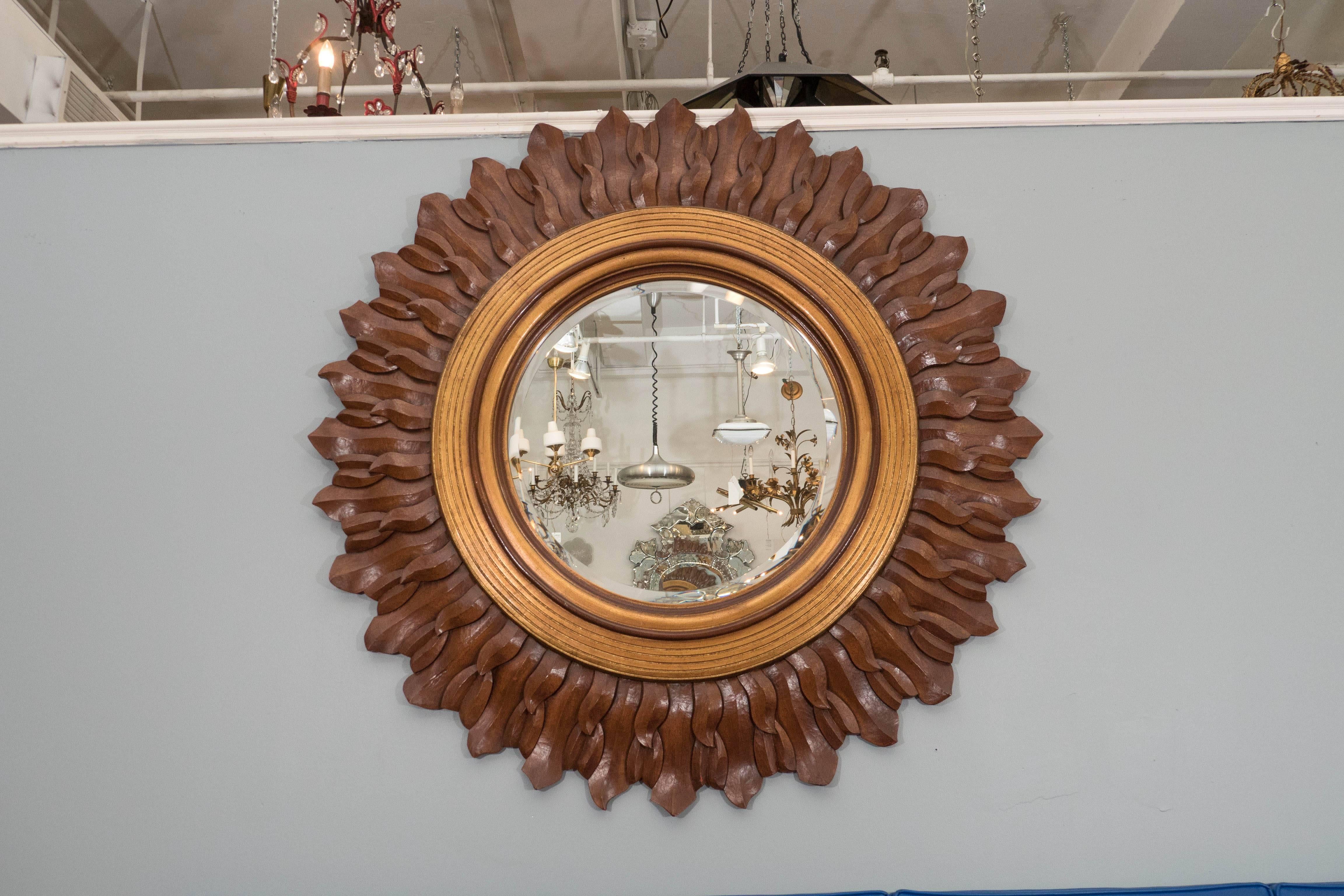 A sunburst mirror, with beveled glass inset within stepped gilded frame, surrounded by rays in carved and antiqued wood. Markings include [CSDF 1998], stamped to the frame. Very good condition, consistent with age and use; mirror measures 23.5
