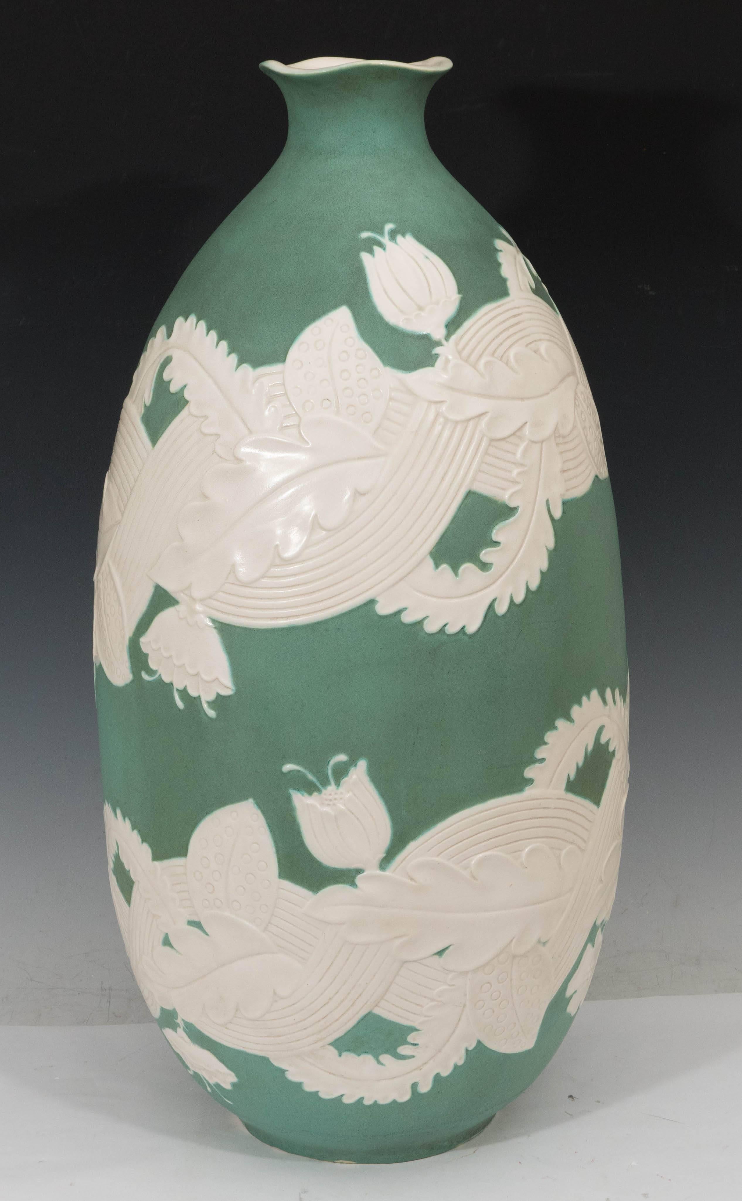 An impressive Italian ceramic vase by ceramicist Giovanni Gariboldi, produced circa 1940s for San Cristoforo-Richard Ginori, with glazed and incised details of intertwining foliate against a green matte ground, with curved rim and white interior.