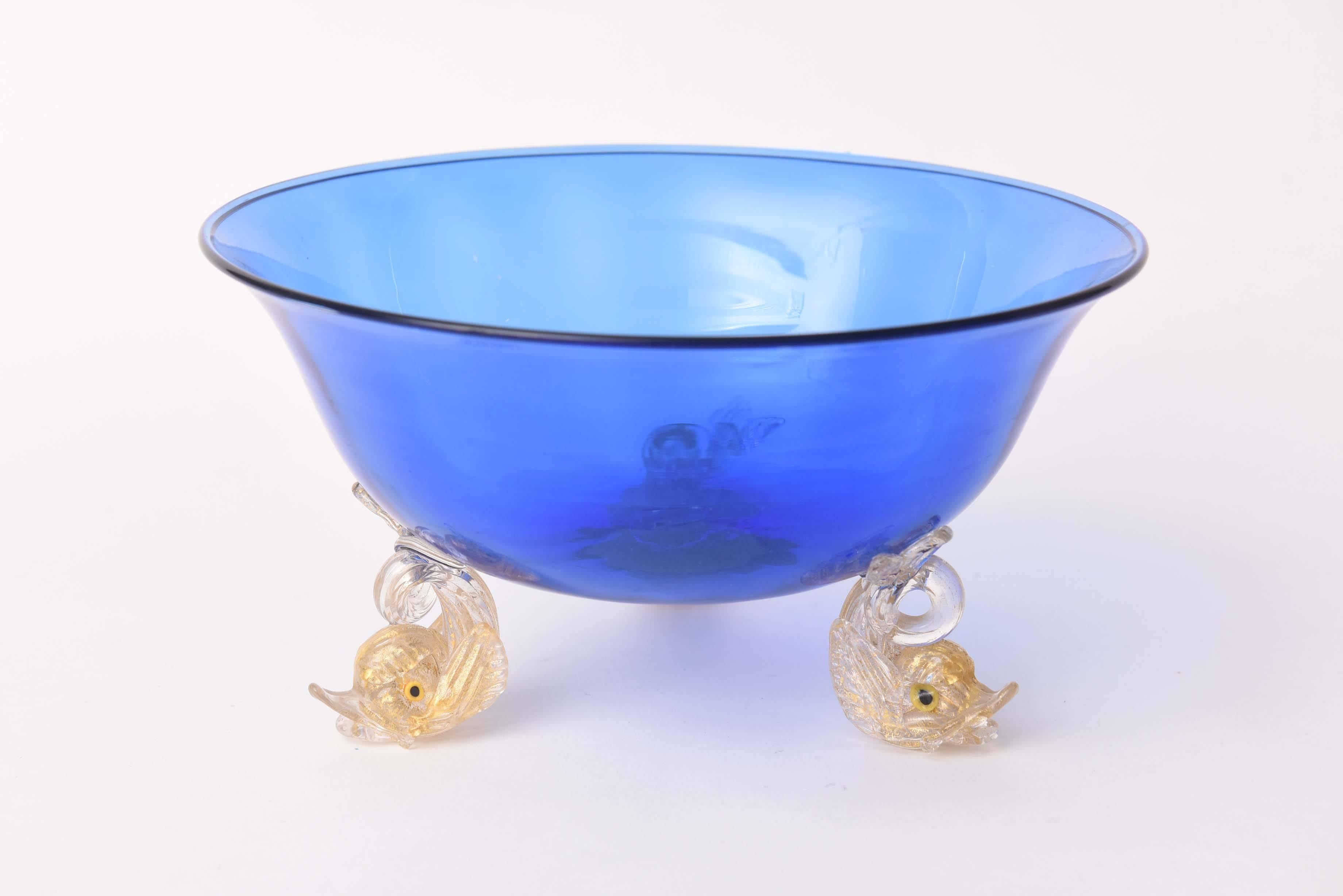A striking piece from the artisans of the Isle of Murano. A rich blown cobalt blue glass centerpiece or fruit bowl featuring three dolphin footed base. A slight flare to the rim and nicely sized. Bottom of the bowl 4.0