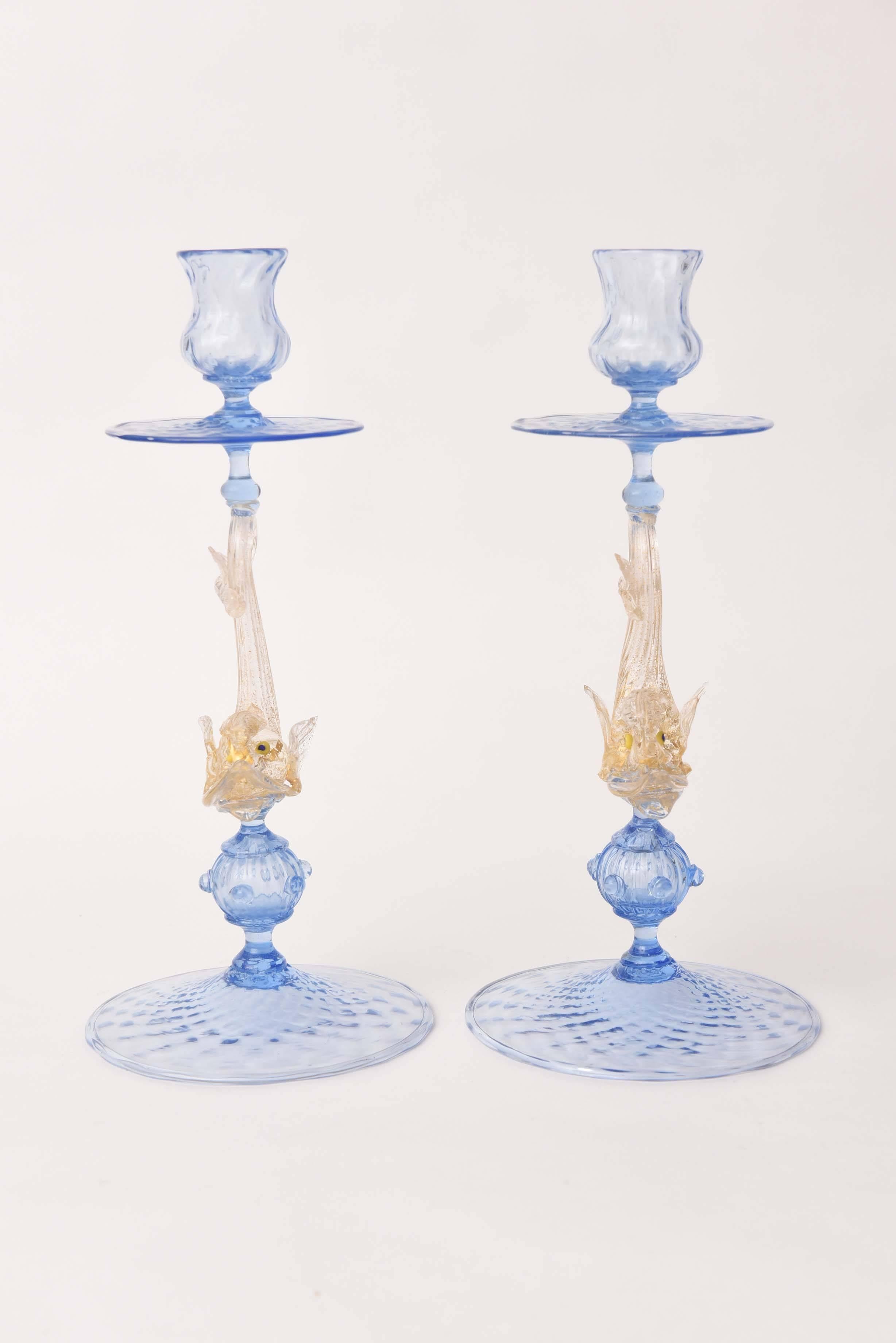 A whimsical and tall pair of Venetian glass candlesticks with a beautifully blown blue bobeche for the candles. Also featuring the Isle of Murano Classic dolphin centering its stem with 24-karat blown gold inclusion. The base features an extra globe