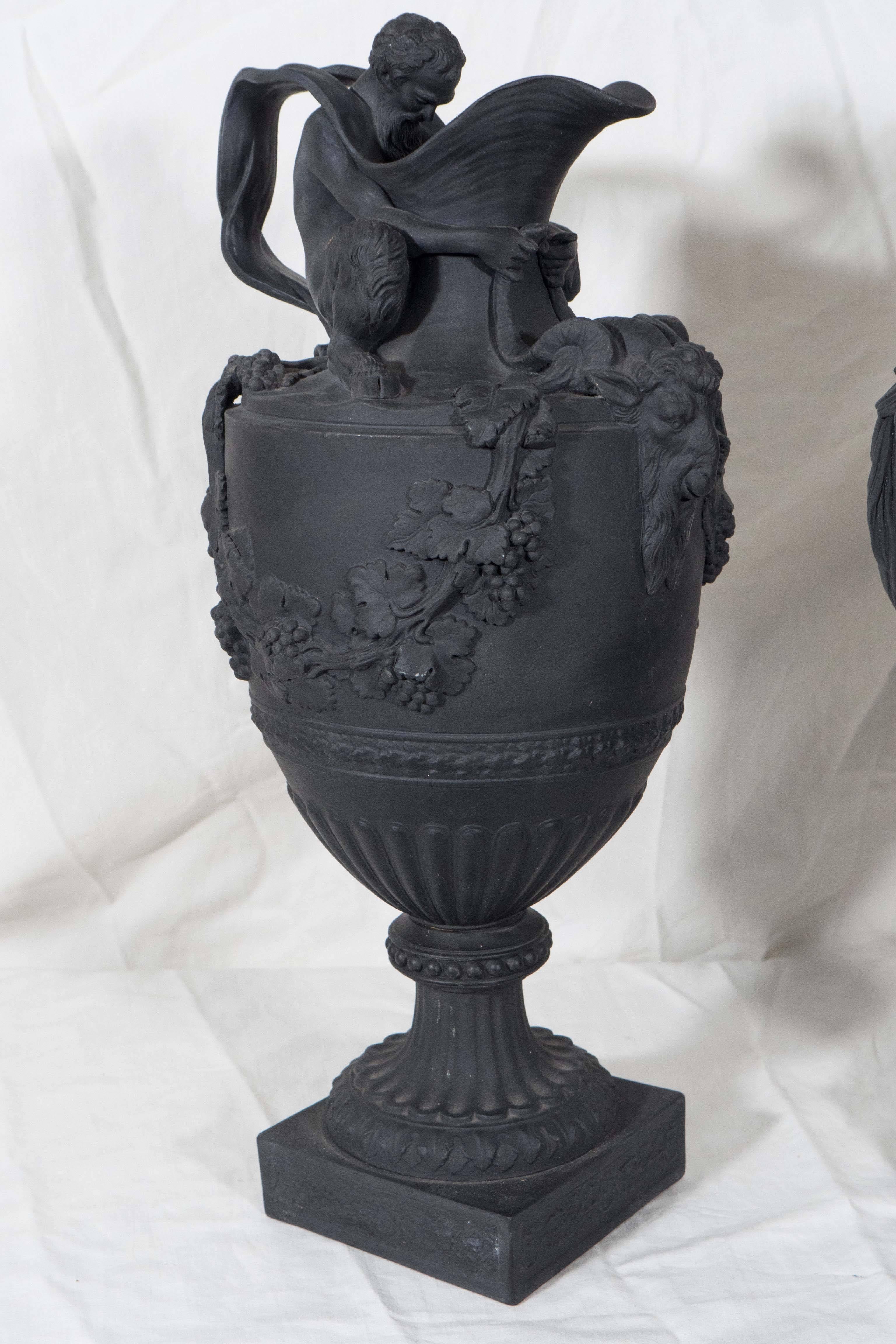 The wine ewer modeled with a figure of Bacchus seated atop the shoulder holding the horns of a ram's head.The water ewer with a figure of Triton seated on the shoulder and holding horns of a marine monster. The wine ewer further decorated with