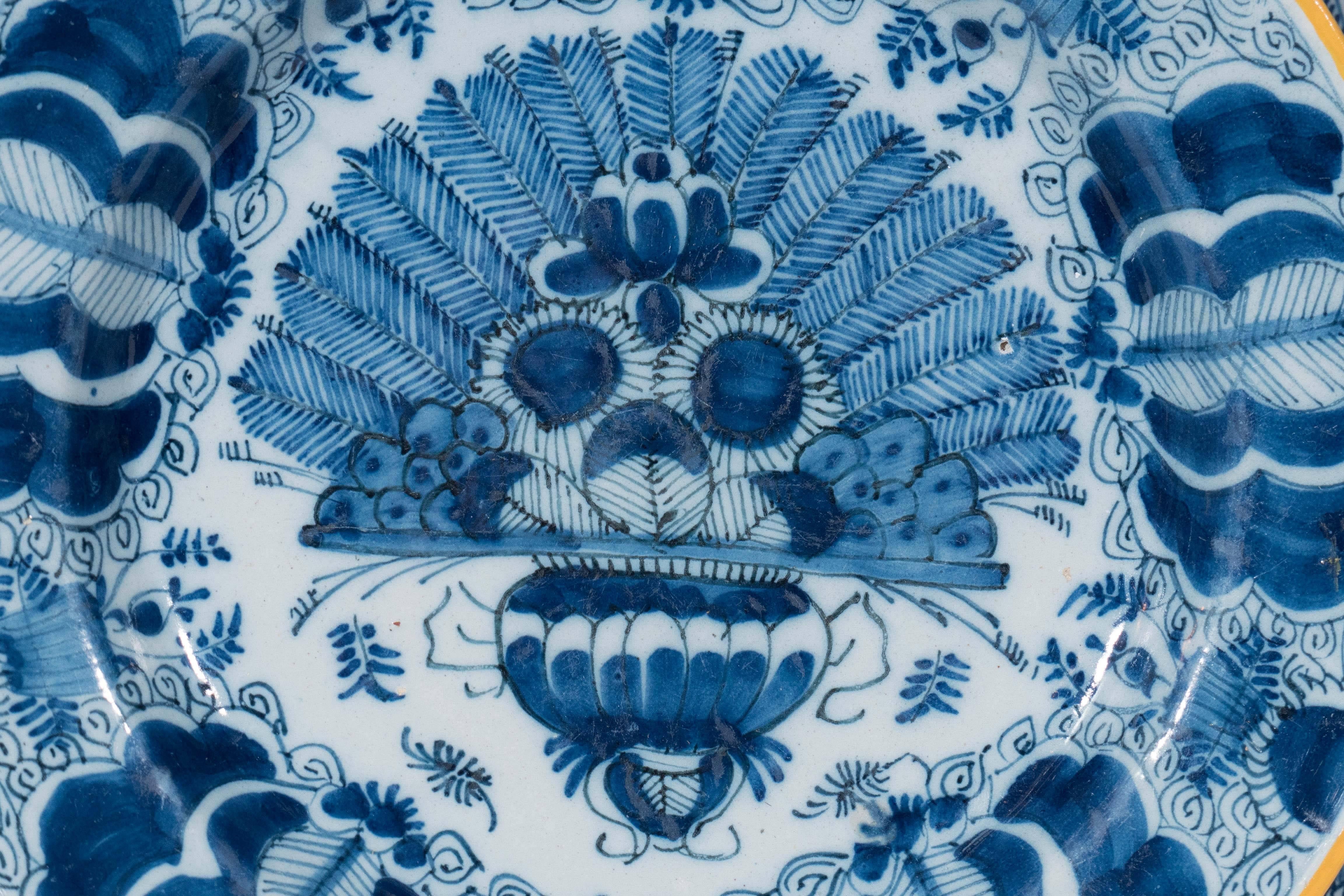 We now have three of these Dutch delft chargers showing a vase filled with sunflowers and ferns. The design is reminiscent of a peacock and is known as the 