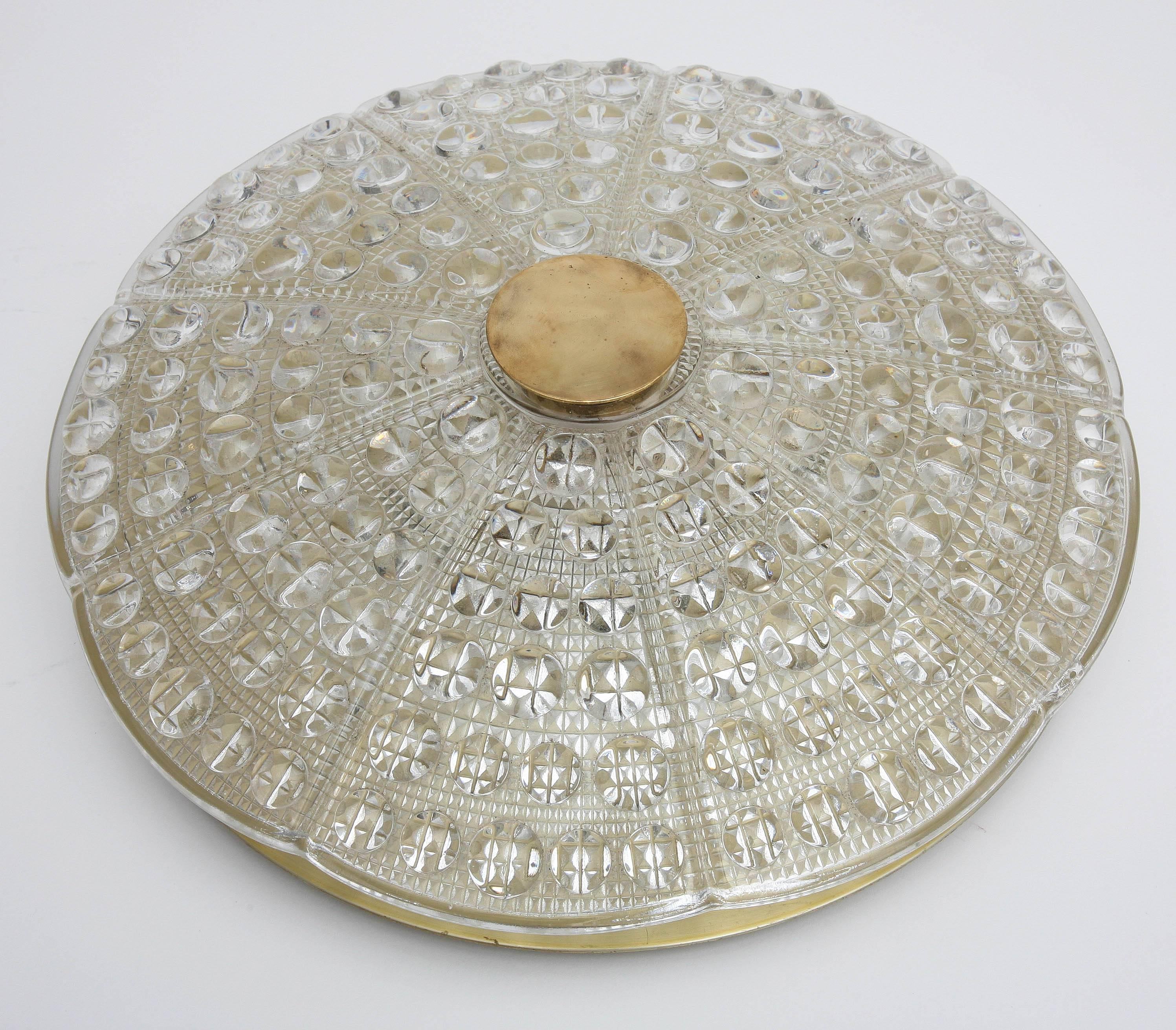 One Orrefors crystal and brass flush mount light fixture by Carl Fagerlund,
Swedish, 1960s The crystal cover has circular raised pattern with a diamond
textured pattern on the bottom, fixture takes six candelabra bulbs, brass backplate and round
