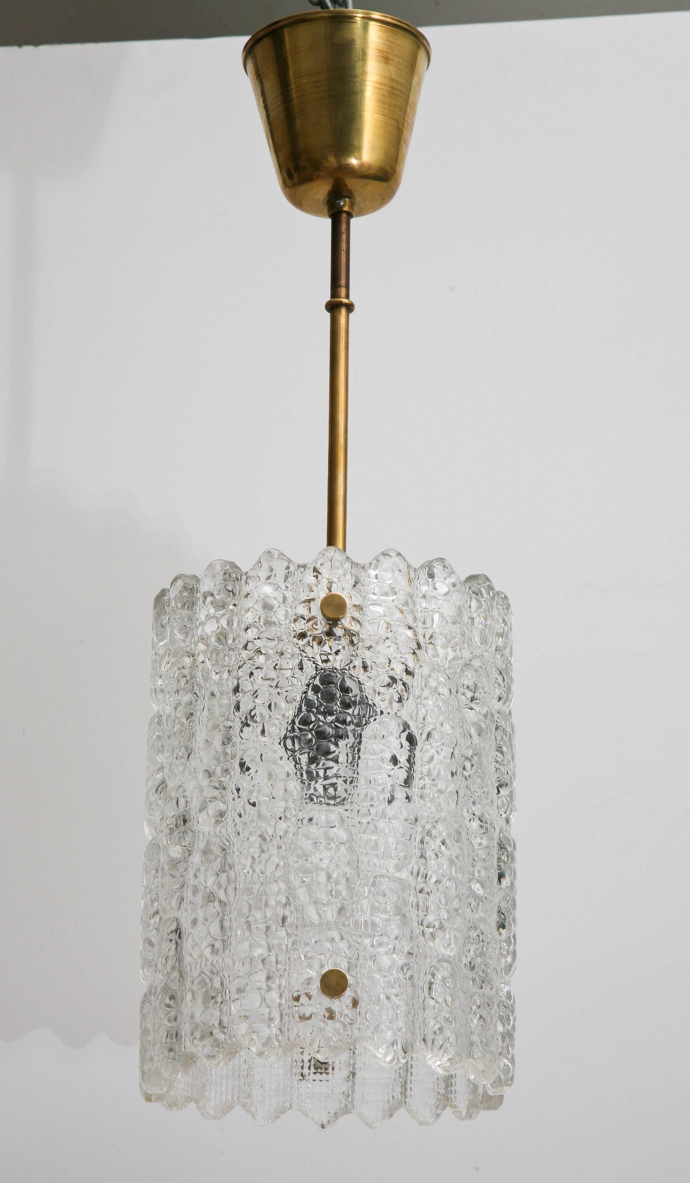 Orrefors crystal pendant light by Carl Fagerlund, Swedish, 1960s.
Classic textured Orrefors crystal design, brass canopy, stem and caps.
One Edison base light bulb  60 watt max, has been wired to US standard.
Measures: 21.00 in H x 7.00 in round.