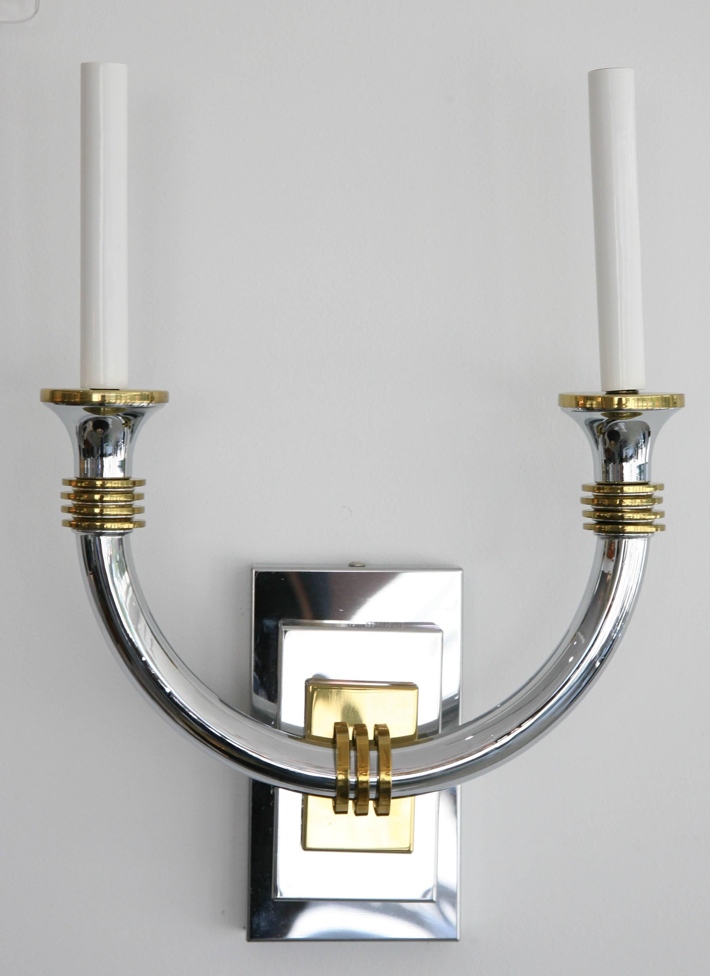 This stylish pair of wall sconces have taken the inspiration for the glamour of the Art Deco period. They are in polished chrome and brass and were produced in Italy.

Note: The lead photo shows flecks on the arms of the sconces. These are
