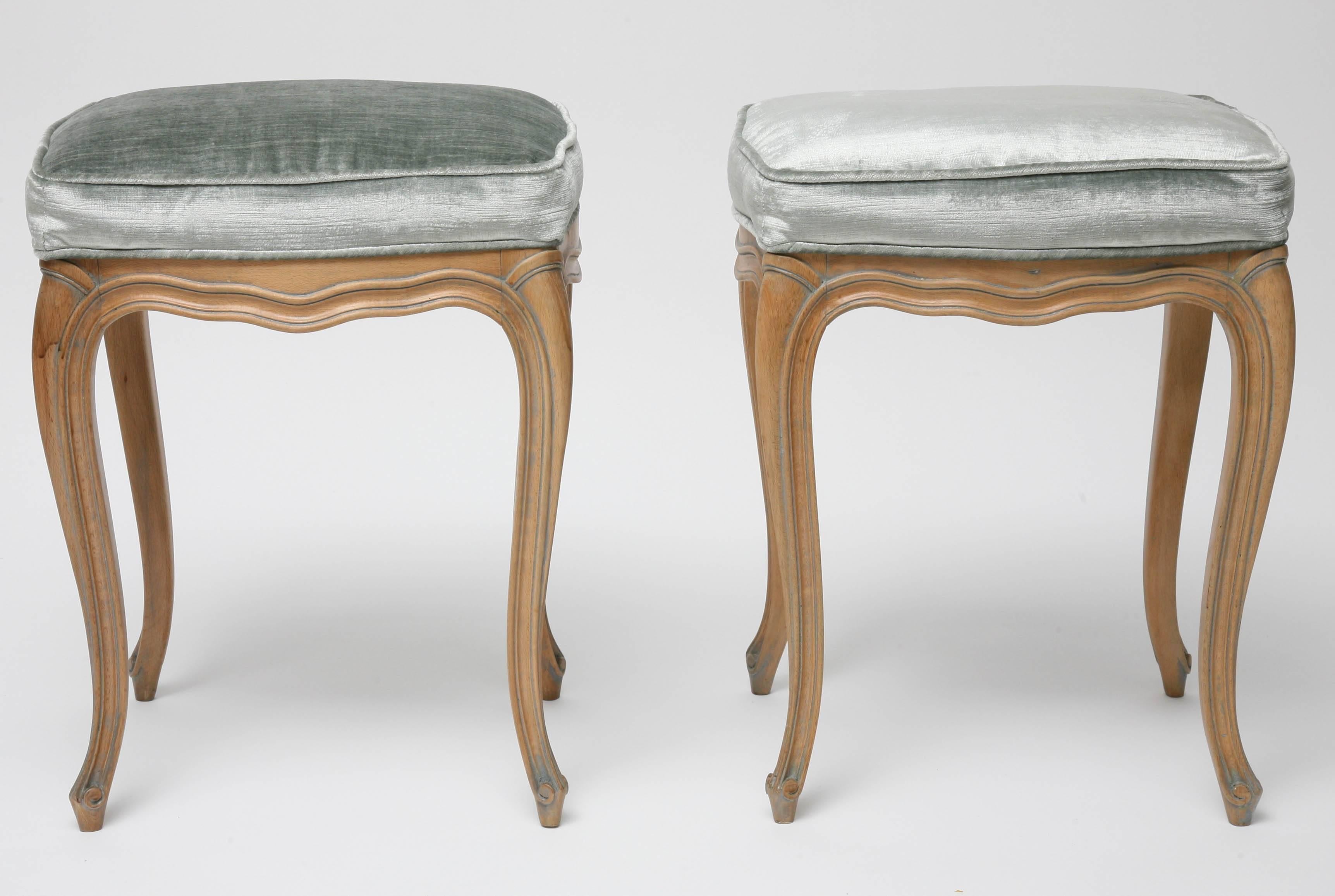 This pair of charming Louis XV style stools were recently acquired from a Palm Beach estate and  have a natural beechwood frame with a blue-over-glaze that highlights the curves of the pieces. The cabriolet legs make these pieces light in appearance