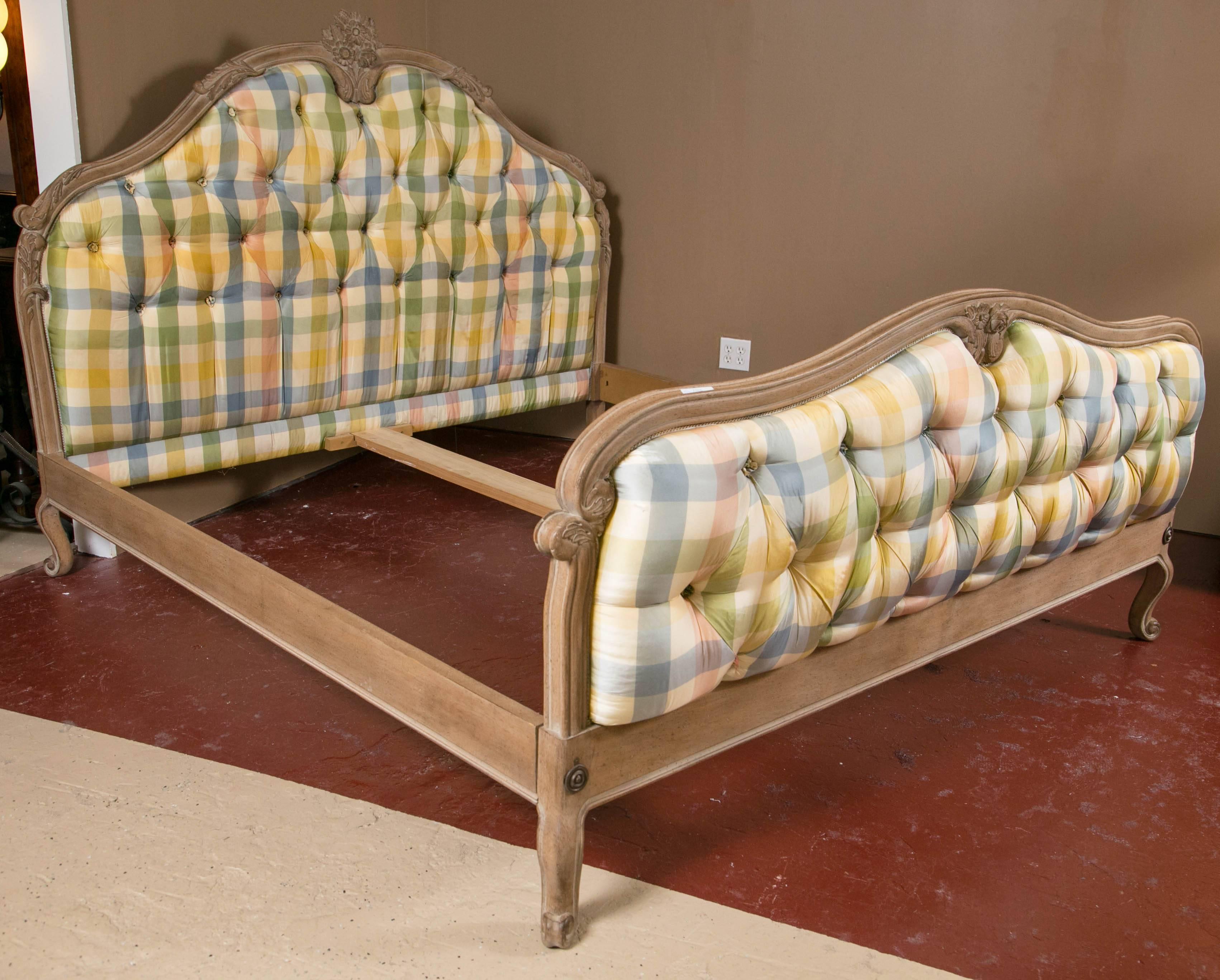 A king-sized Louis XV style country French bed. Custom quality by Don Rousseau, This fun checkered upholstered in light pastel colors headboard and foot-board is tufted and sits on a thick and supportive Louis XV Styled frame. The fame with a center