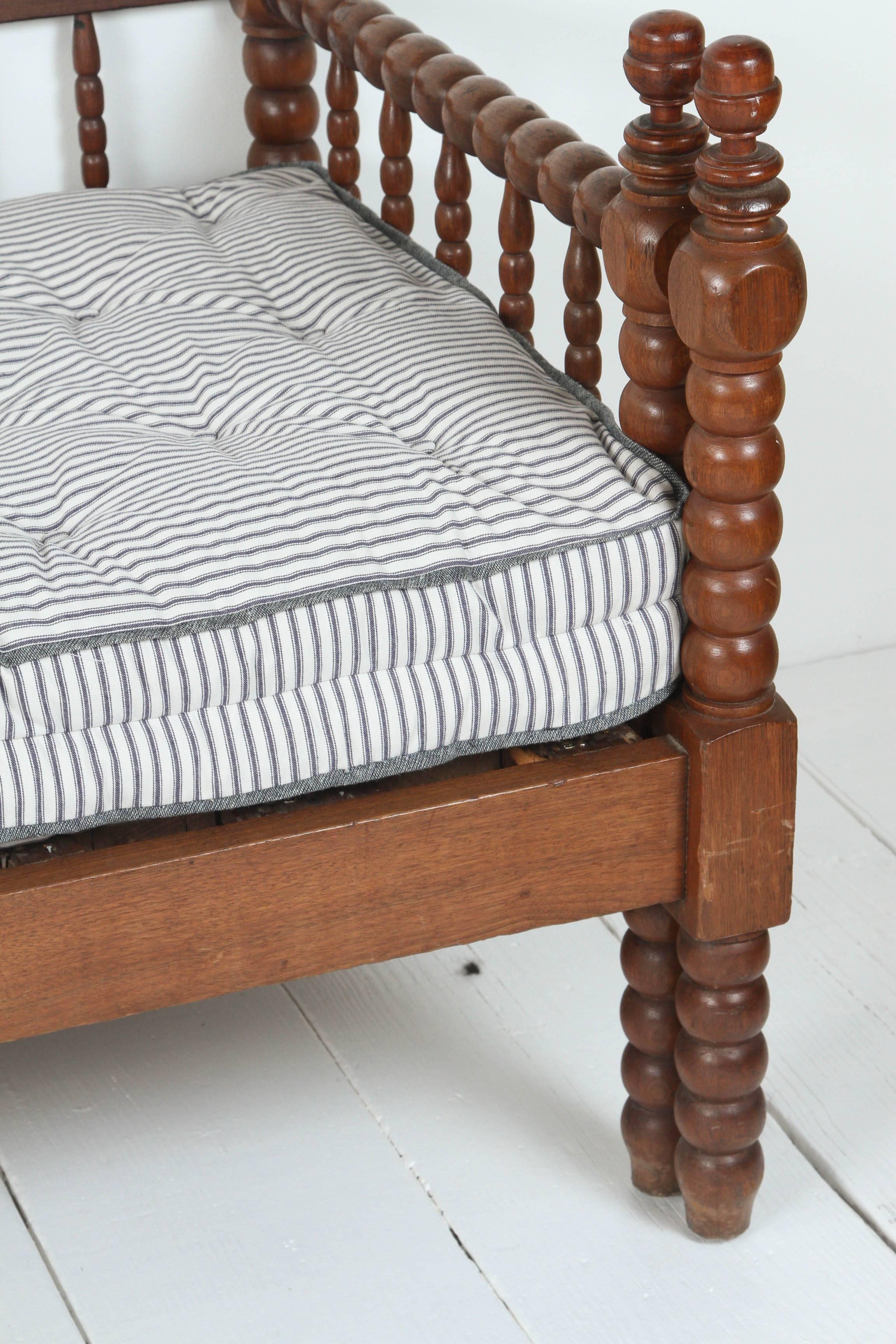 Vintage American spindle daybed with pull-out trundle with tufted striped mattress.