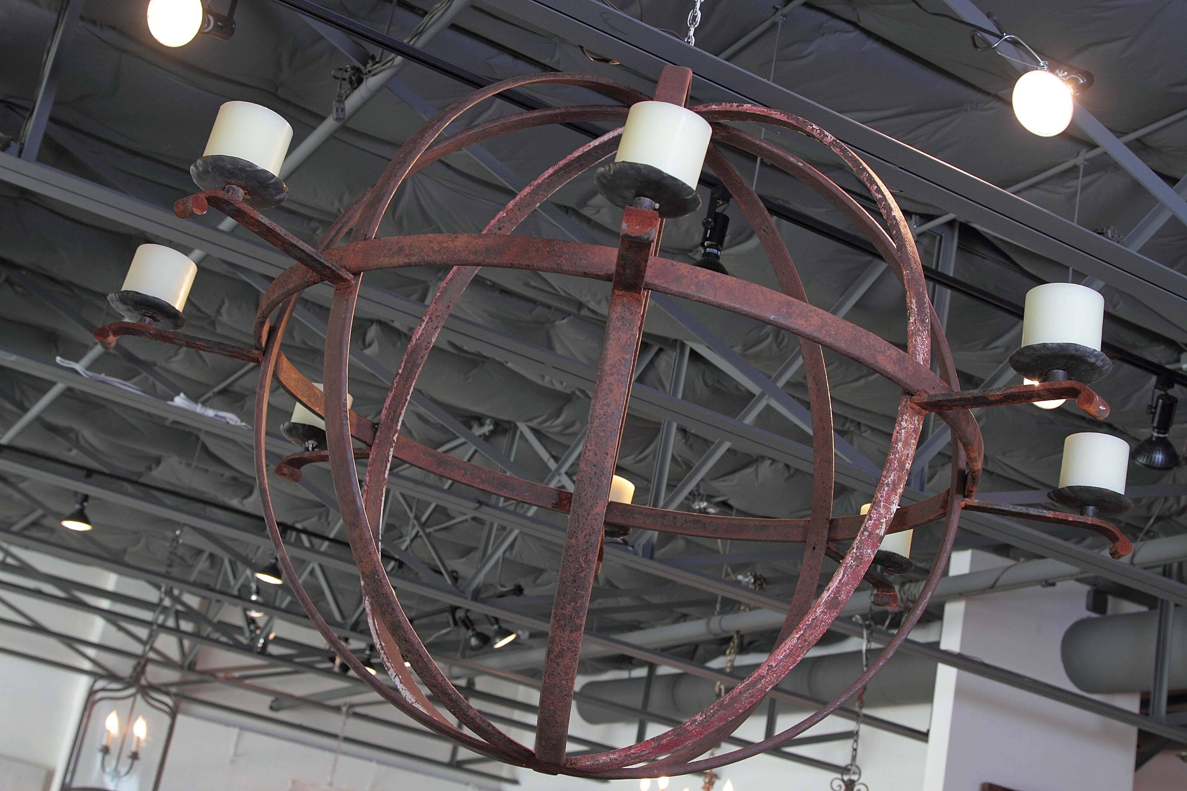Large Industrial Orb eight-candle chandelier, 
Made with Circa 1900  metal wheels used in industry.
 Original rust patina with eight iron metal candleholders. 
For indoor or outdoor use.

Can be electrified, contact us for quote.