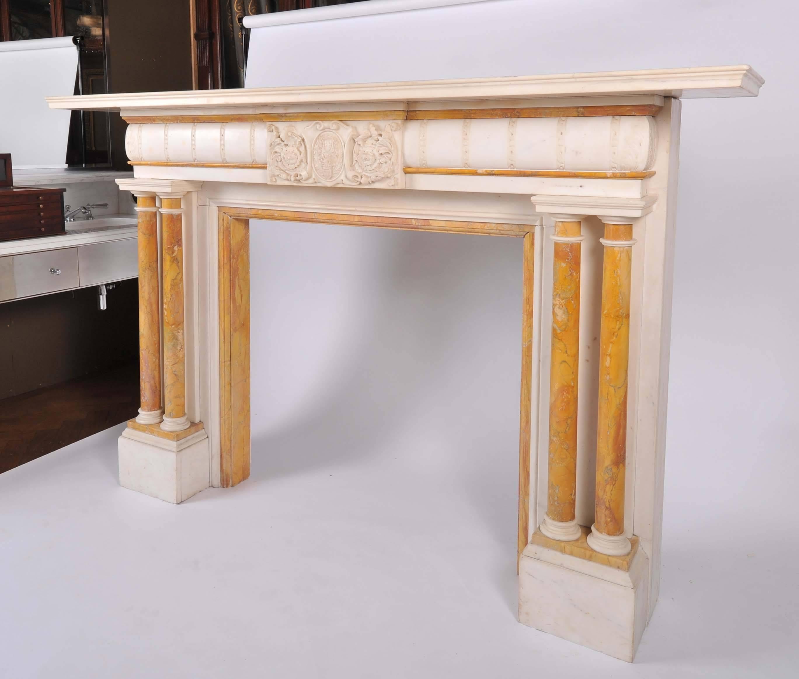 A spectacular 19th century fireplace surround in statuary marble with sienna marble inlay. This original antique fire surround is in grand proportions with an architectural design in the Palladian style. Each jamb features a pair of sienna marble
