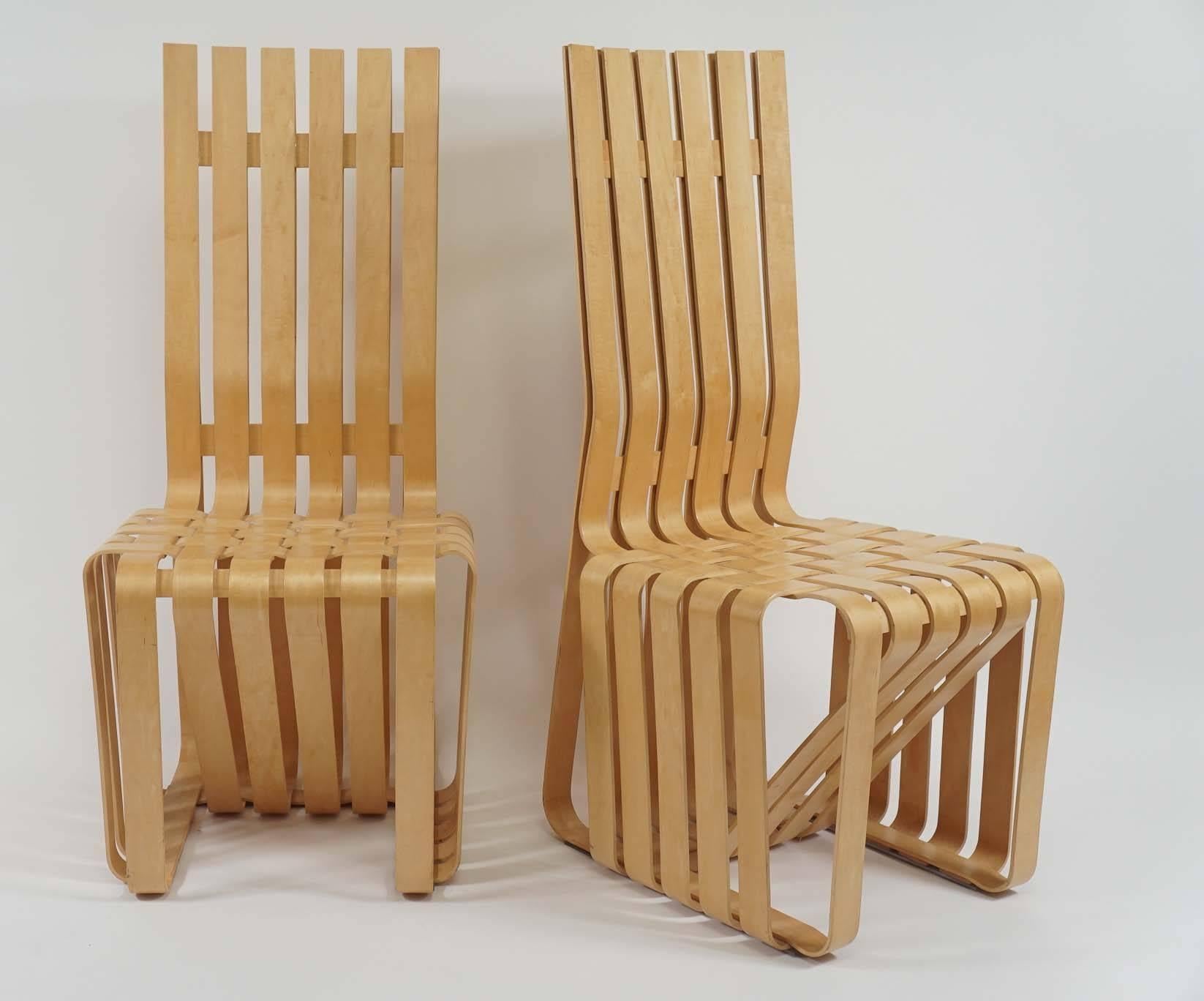A wonderful pair of sculptural chairs by Frank Gehry. Inspired by the strength of apple crates, he created these woven bent maple chairs. They retain the Knoll and Gehry signature along with the date they were made. One is missing the plexi glide on
