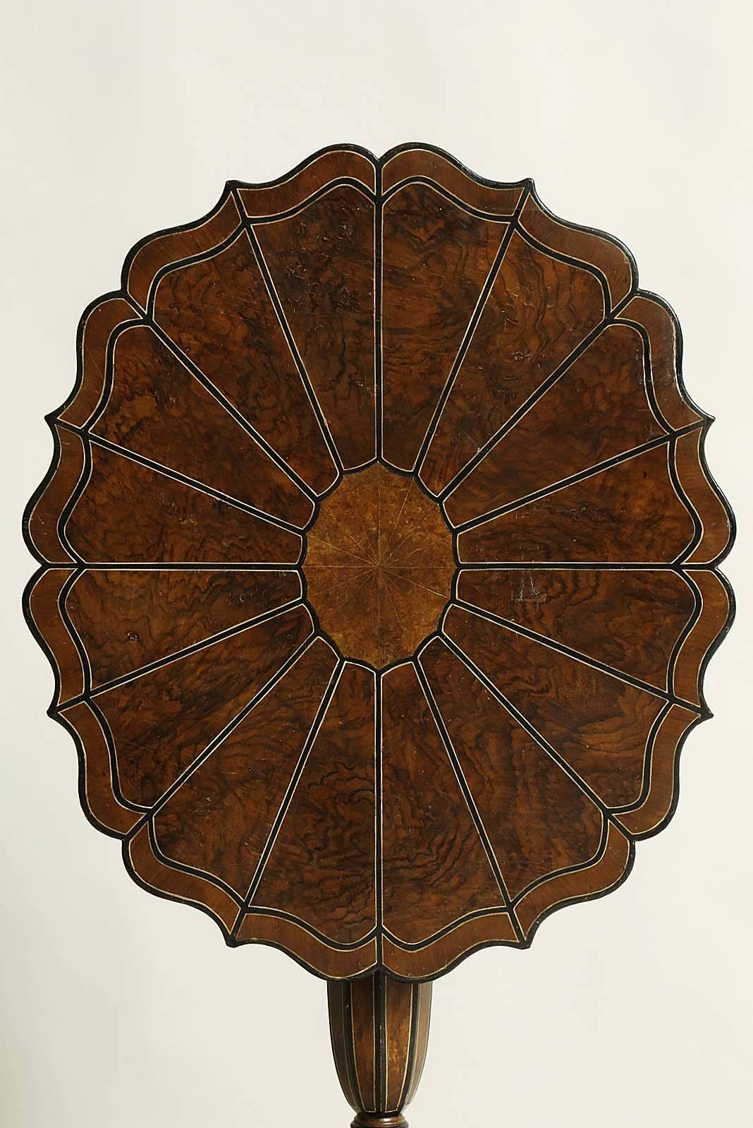 Unusual 19th century Swedish tilt-top table with scalloped top having faux painted marquetry top, over octagonally shaped shaft, standing on scrolled legs, the whole painted in simulated walnut, ivory and salamander and having graphic form.