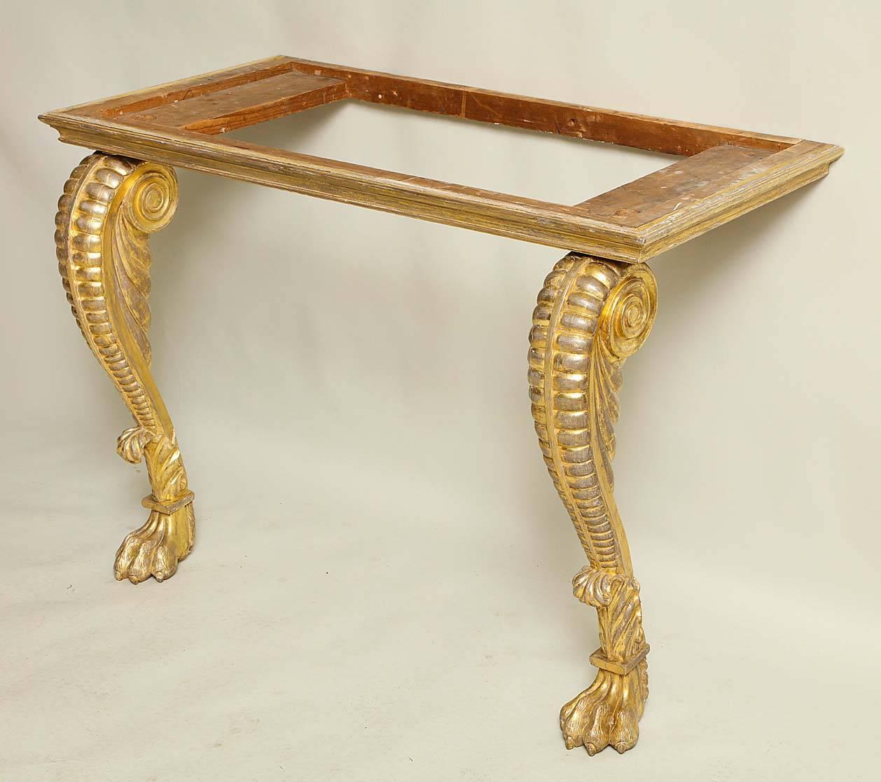 Very fine Irish Regency giltwood pier table, the Mona marble-top over simple shallow molded apron, standing on boldly carved scrolled and ribbed legs with acanthus collars and lion paw feet, retaining original and richly burnished and rubbed gilding