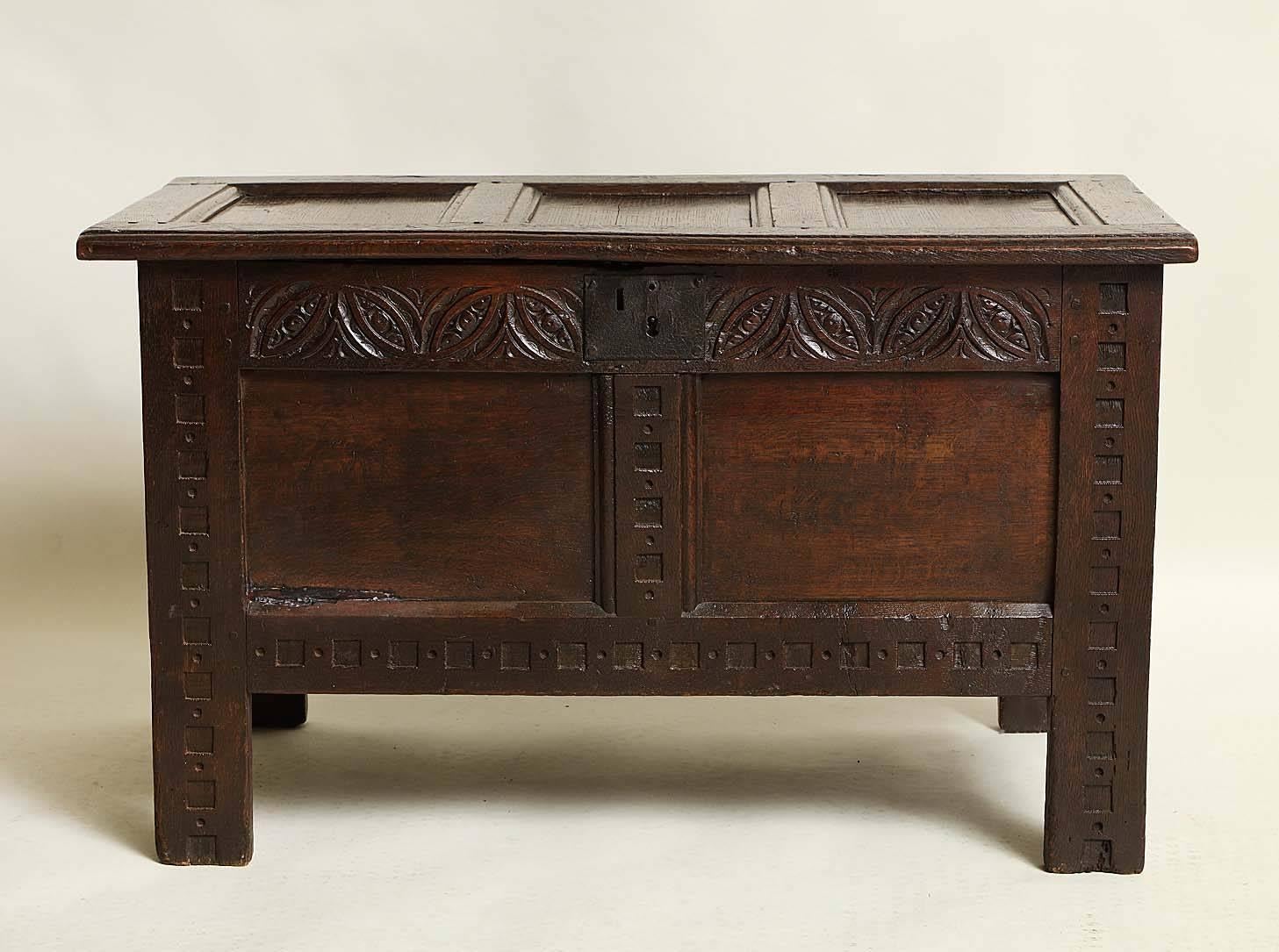 Good 17th century English oak coffer, probably Gloucestershire or West Country, the three panel top with molded rails and stiles, the font richly carved rails and stiles, having original lock plate, the whole with very rich color and of pleasing