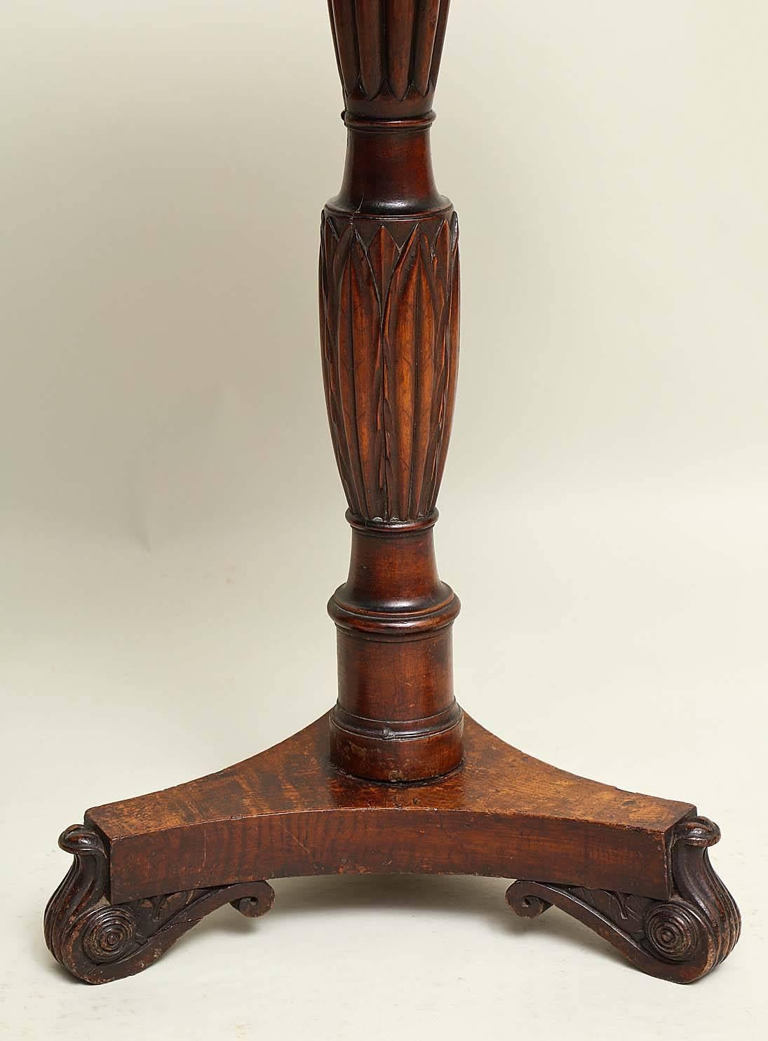 Quirky early 19th Century English burl oak circular table with richly grained solid burl top over turned and long leaf carved shaft over burl tri-corner base having two carved and rosette embellished feet and one silhouetted foot with traces of