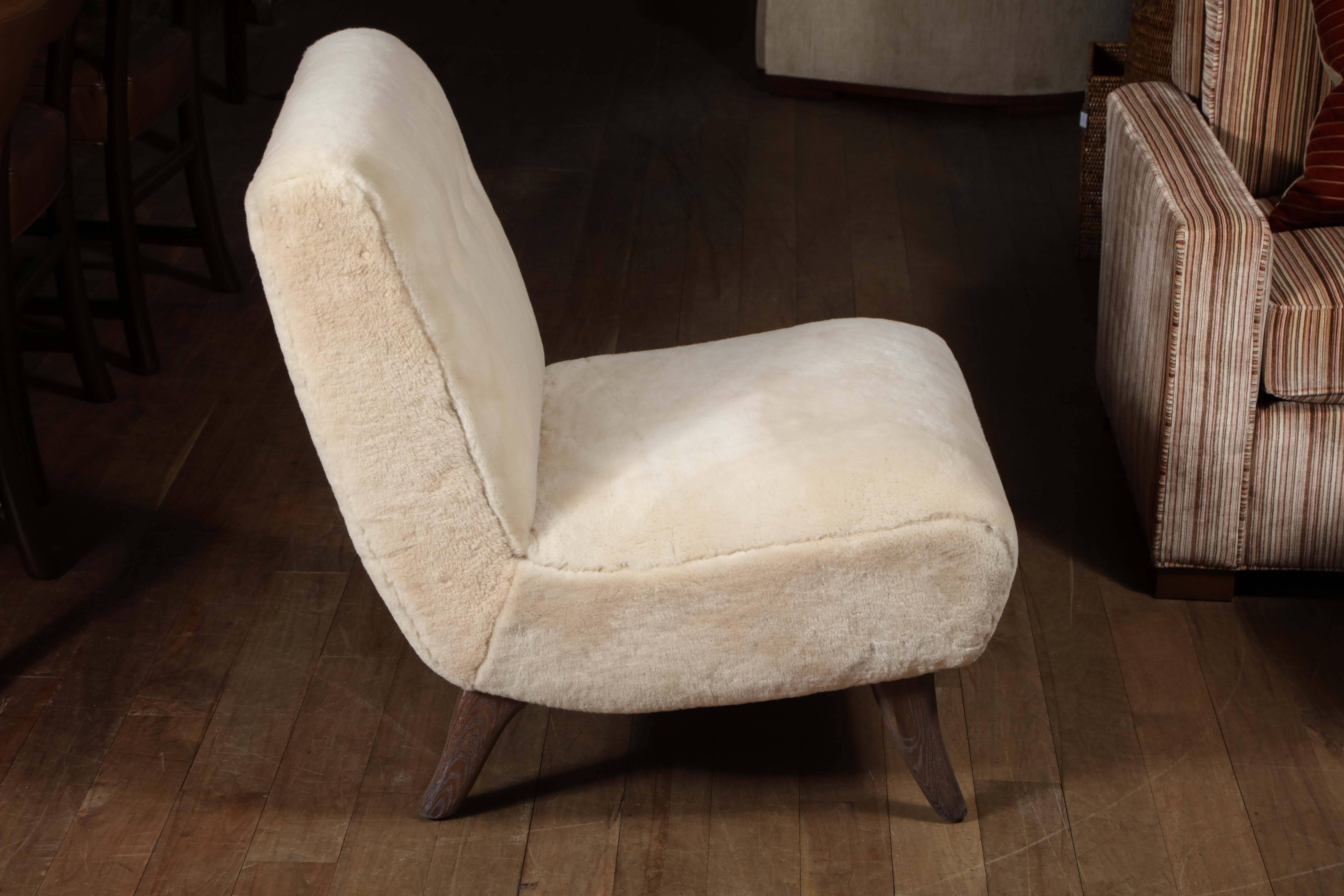 Pair of shearling upholstered slipper chairs with bone leather buttons and cerused oak feet, circa 1950.