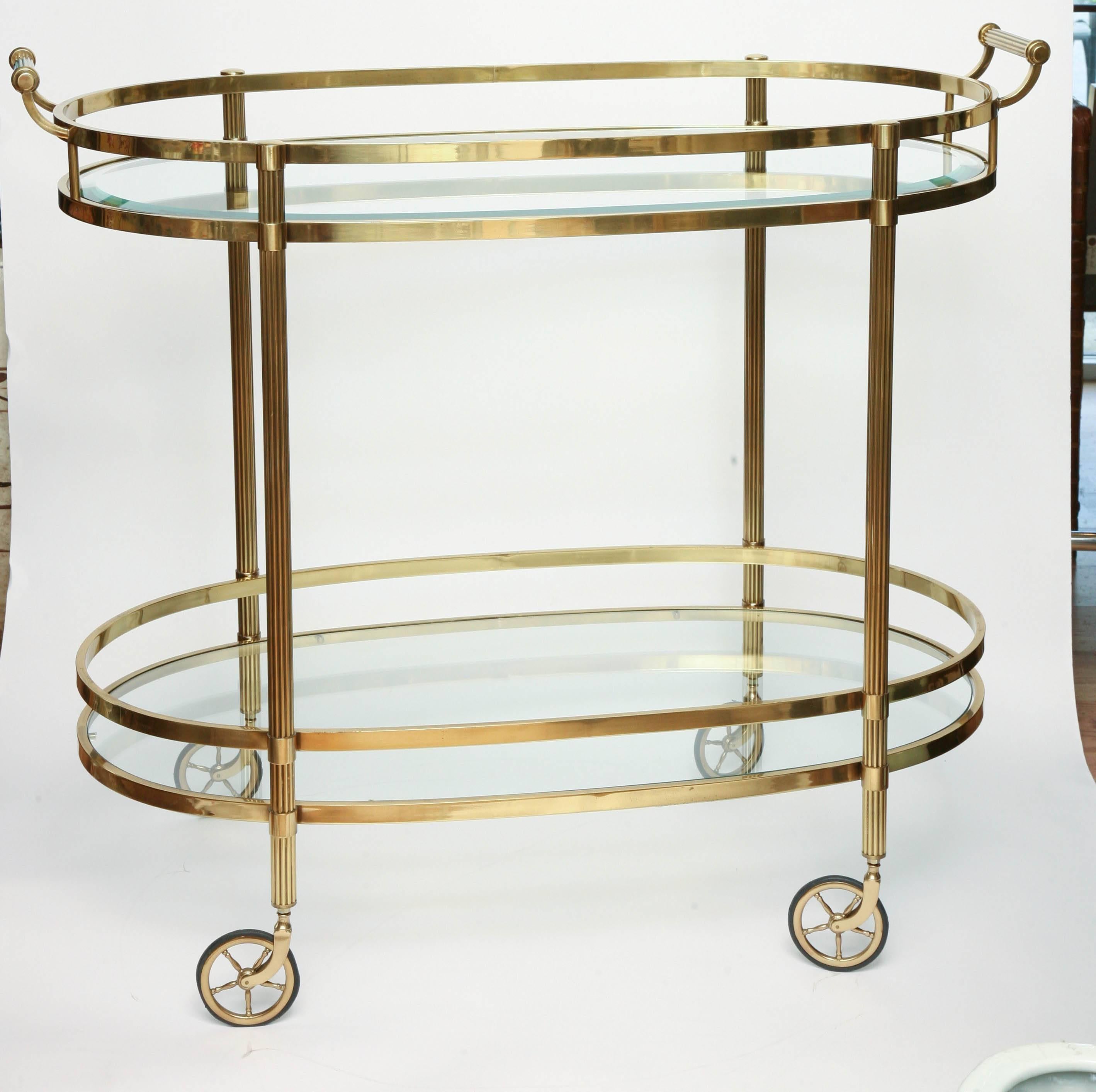Exceptional two-tiered brass bar cart with glass shelves.