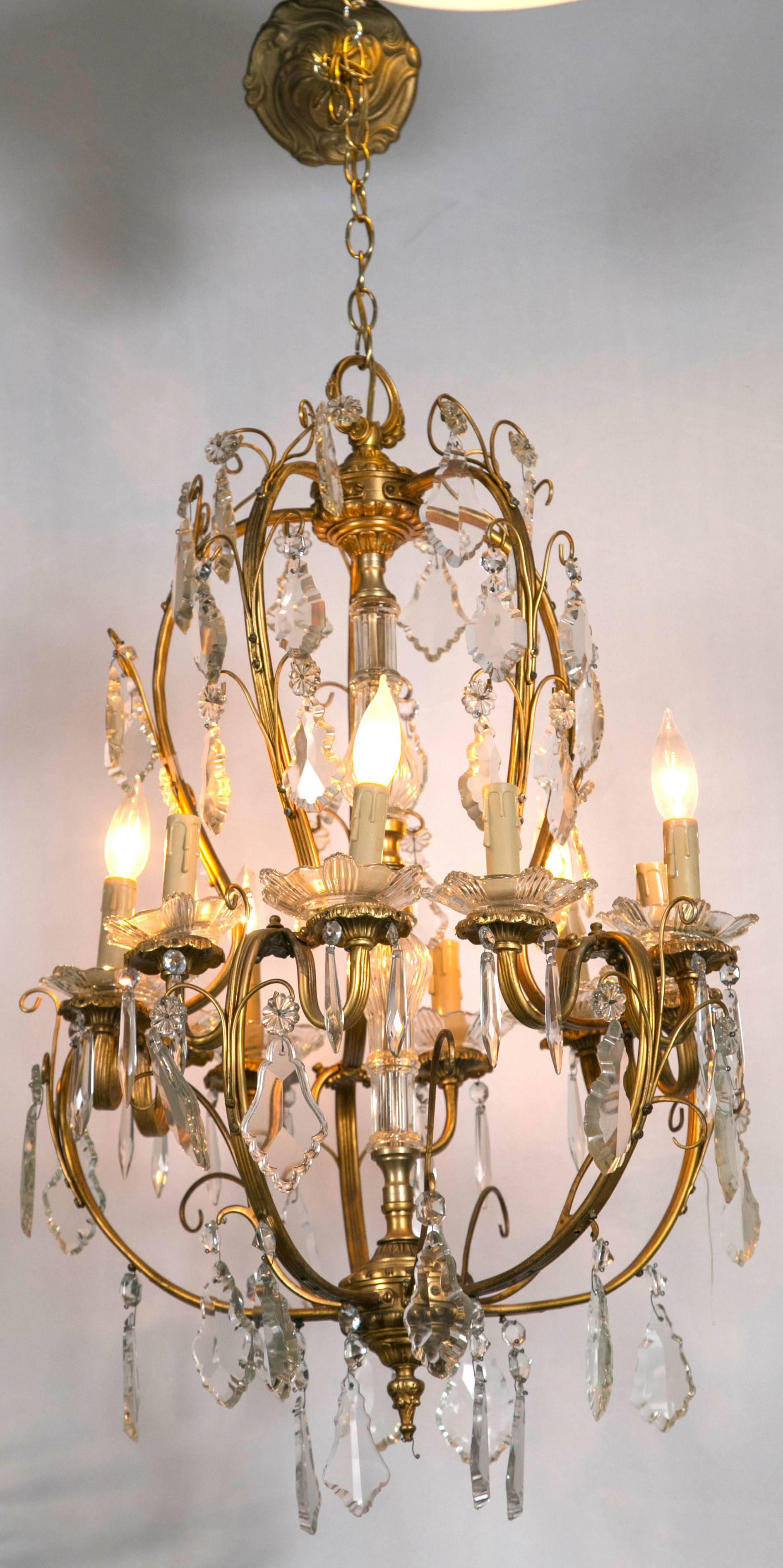 A fine vintage French bronze and crystal chandelier. Having a central glass column with all-over swag and flowing bronze arms this Louis XVI style chandelier would look fantastic in any dining room, hallway or the like. The crystal bobeches under