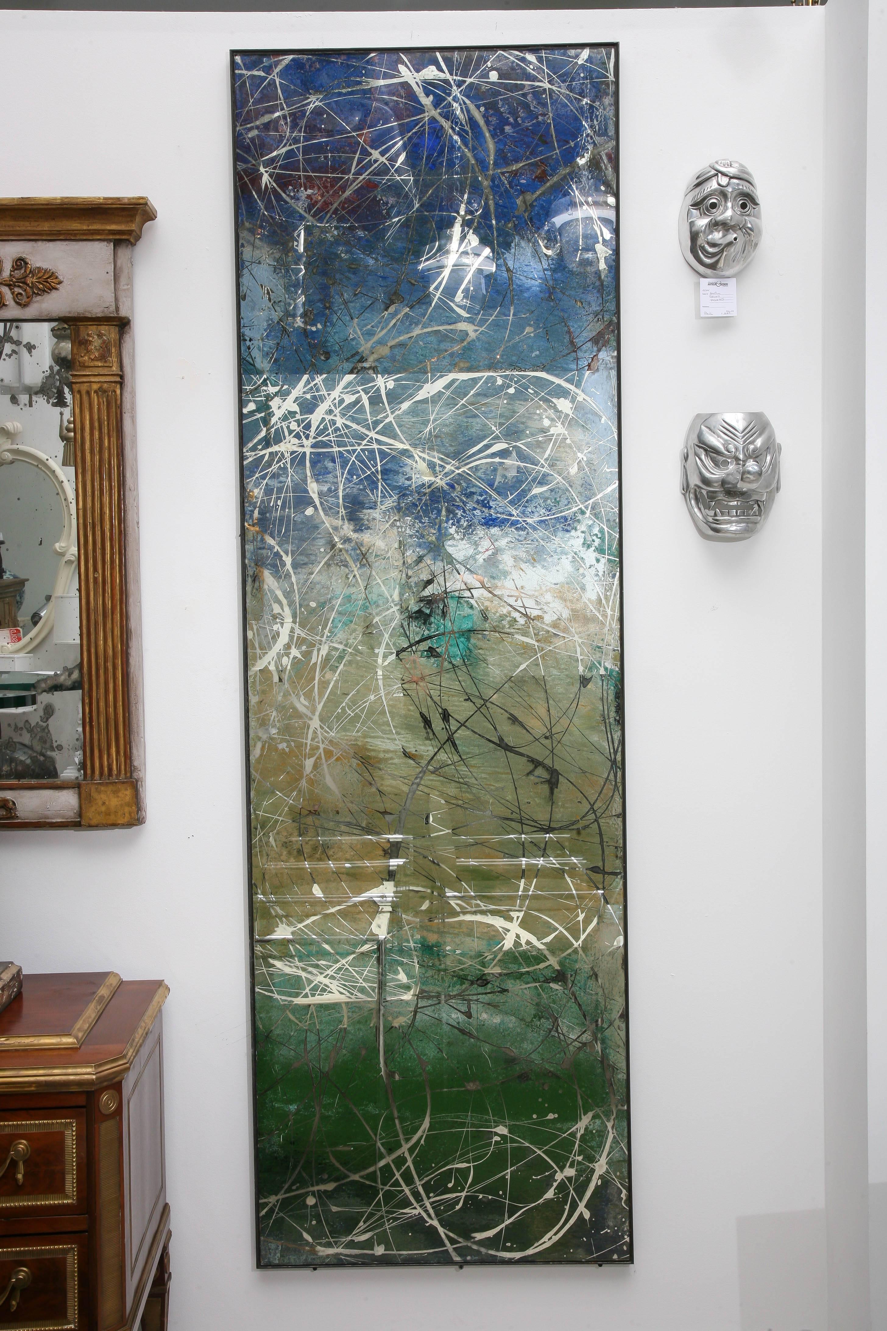 Pair of reverse painted rectangular mirrors with multicolored splatter pattern. The palette ranges from blue to green to yellow ochre.