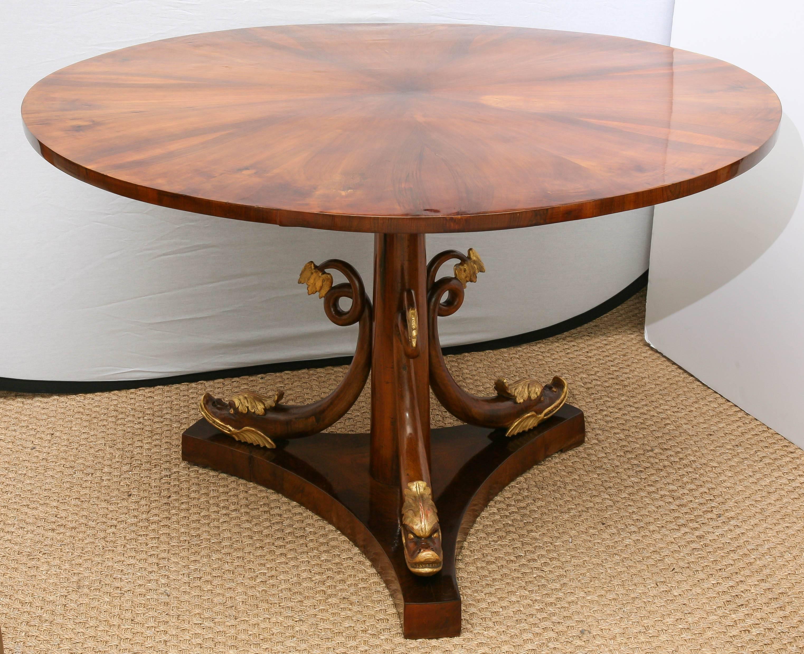 Exceptional Viennese Biedermeier center or dining table with circular flip-top so detailed that even the underside has walnut veneer as masterfully crafted as the top. The carved creatures as the base may be described as snakes or dolphins. They