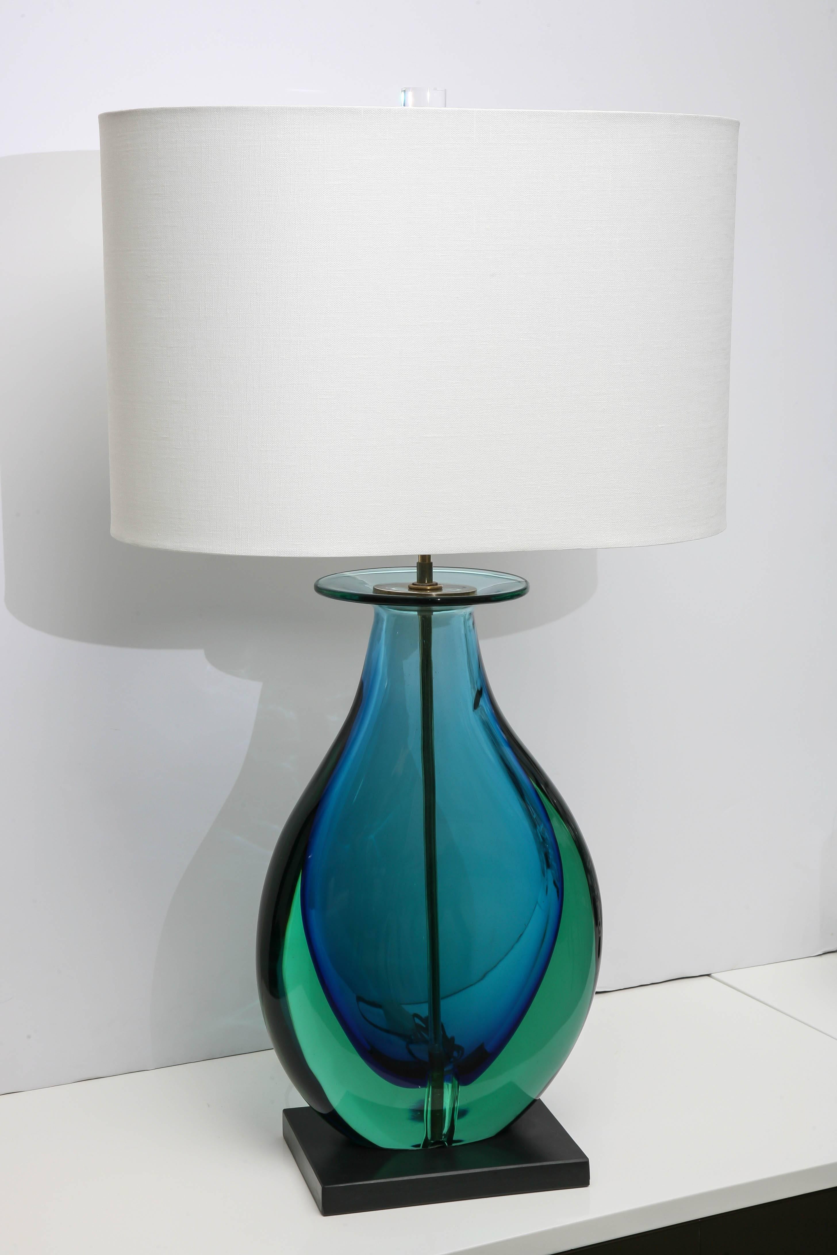 Pair of rare Murano glass lamps by Flavio Poli. The lamps are aqua and marine blue, the technique is Sommerso. The lamps have new custom shades harps and finials.