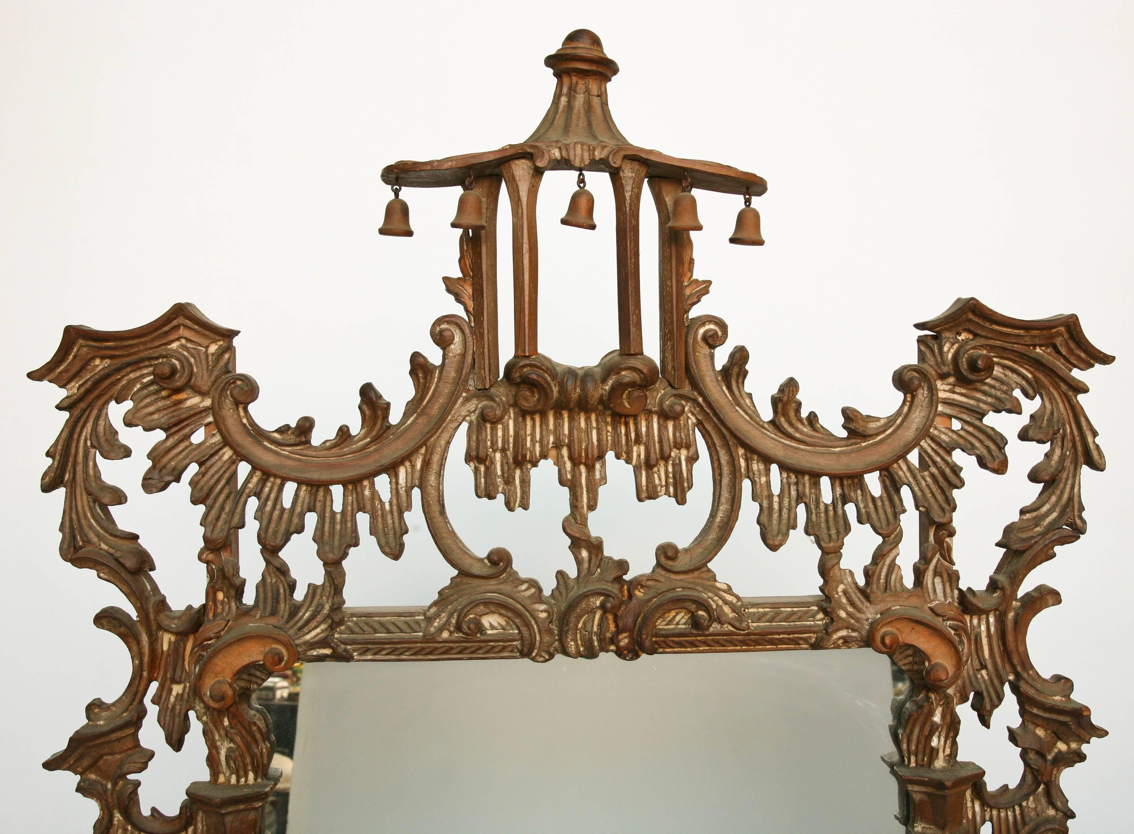 
The elaborate and intricately carved mirror, in the Chinese Chippendale manner,
is adorned with hanging 