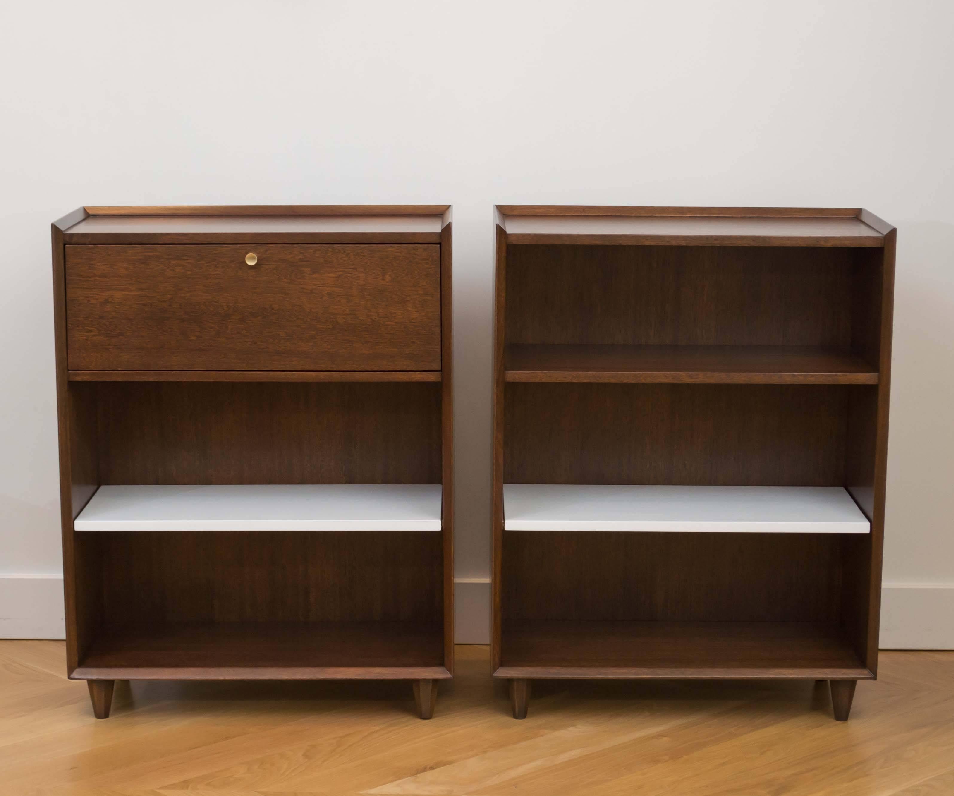 Beautifully refinished pair of mahogany shelves by Gilbert Rohde for Brown Saltman. One of the shelves has a small pull down that becomes a writing desk, with a white lacquered adjustable shelf.